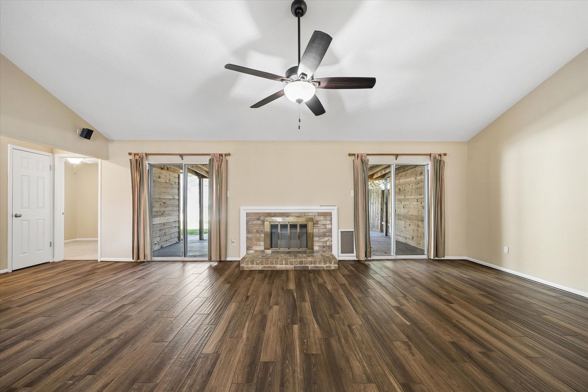 Gather around the fireplace, enjoy the natural light, and imagine relaxing evenings in this spacious living room with backyard access.