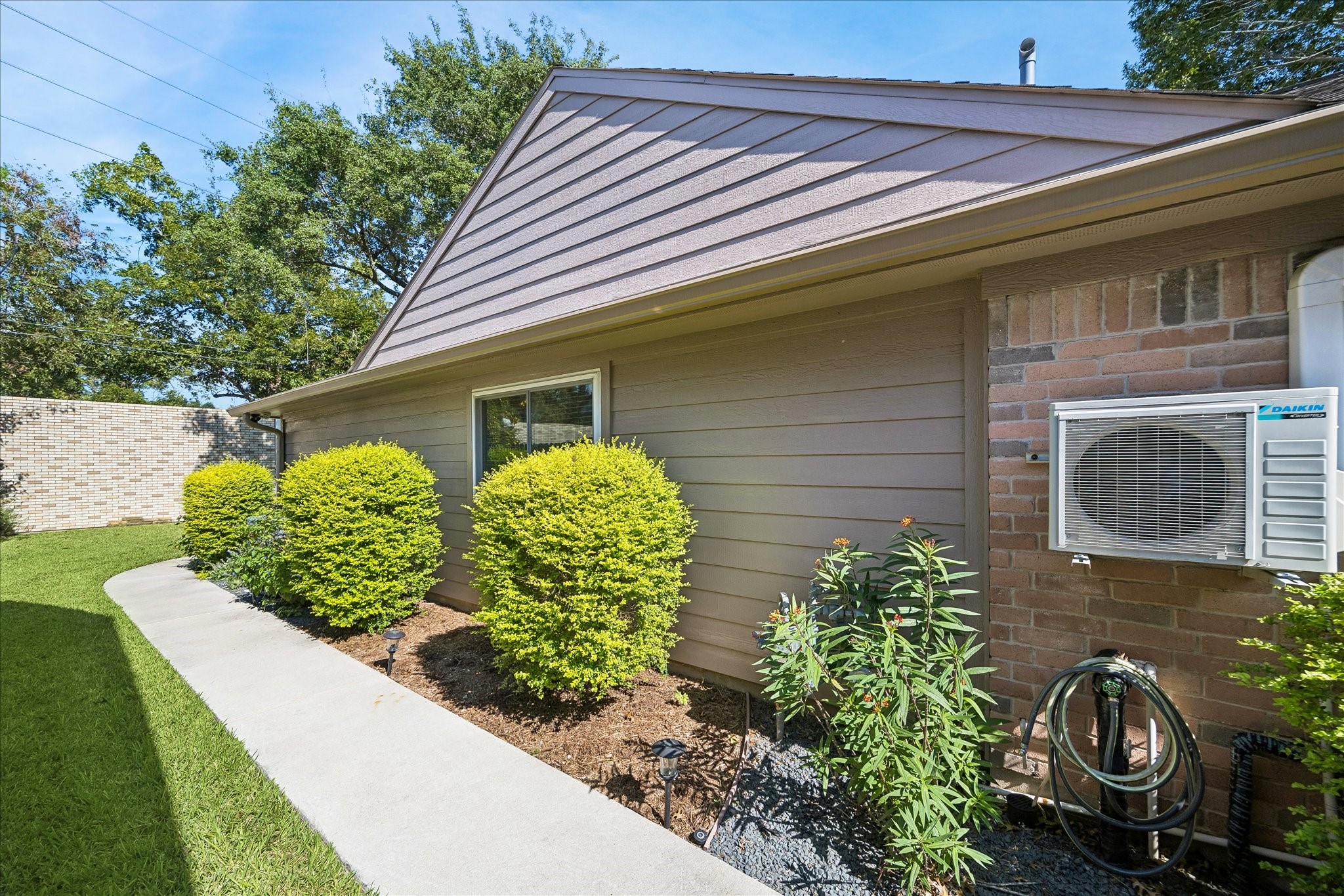 Neatly maintained landscaping and a convenient side walkway add to the home's inviting outdoor appeal