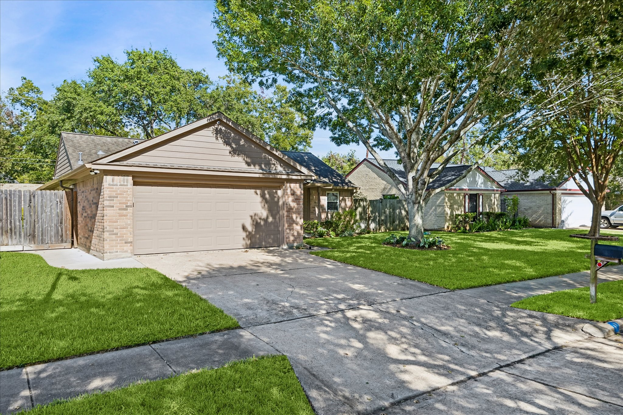 A welcoming front lawn, mature shade trees, and a spacious driveway create a lovely first impression.