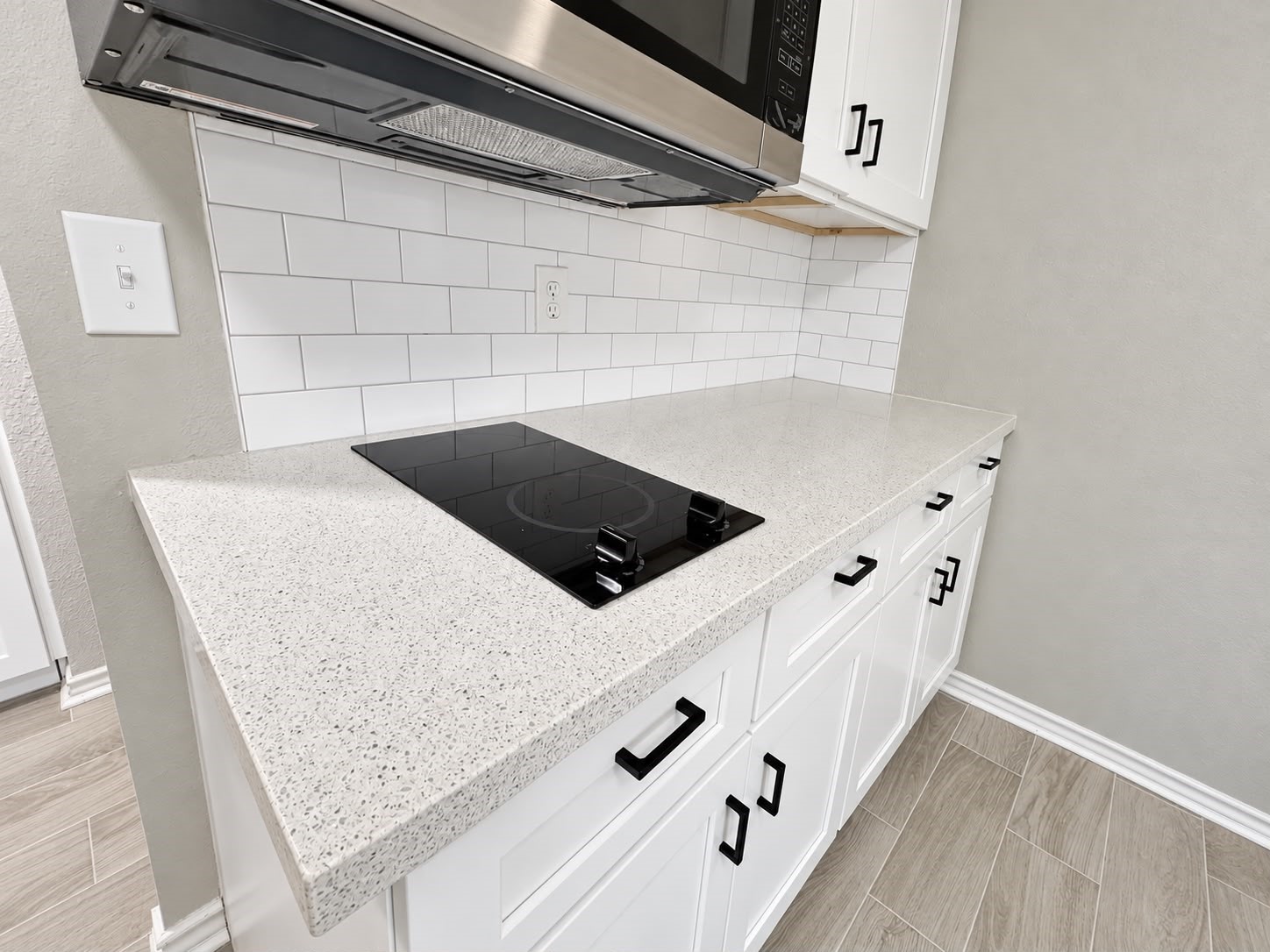 Kitchenette featuring sleek countertops and white subway tile backsplash.