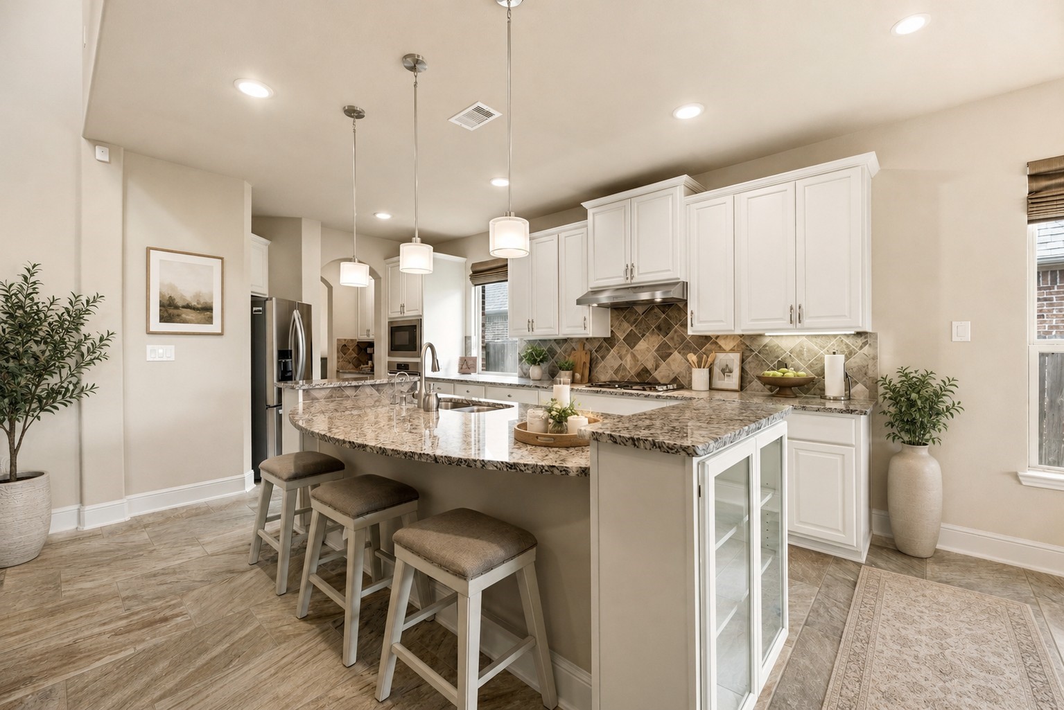 The island can serve as a breakfast bar and offers glass doored cabinets at both ends. The French door refrigerator will stay. (virtually staged) The island can serve as a breakfast bar and offers glass doored cabinets at both ends. The French door refrigerator will stay. (virtually staged)
