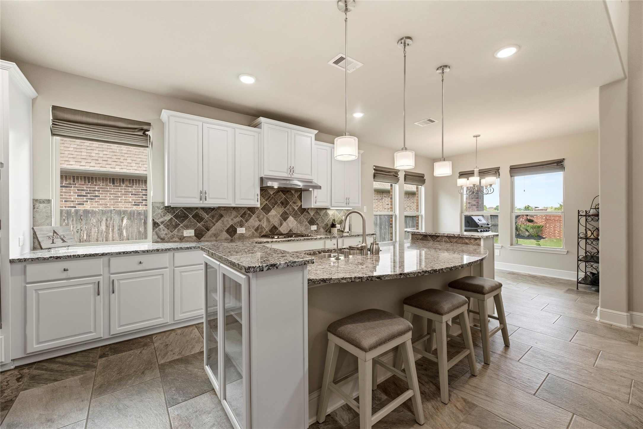 This fabulous kitchen features white cabinetry, granite counters and stainless appliances.