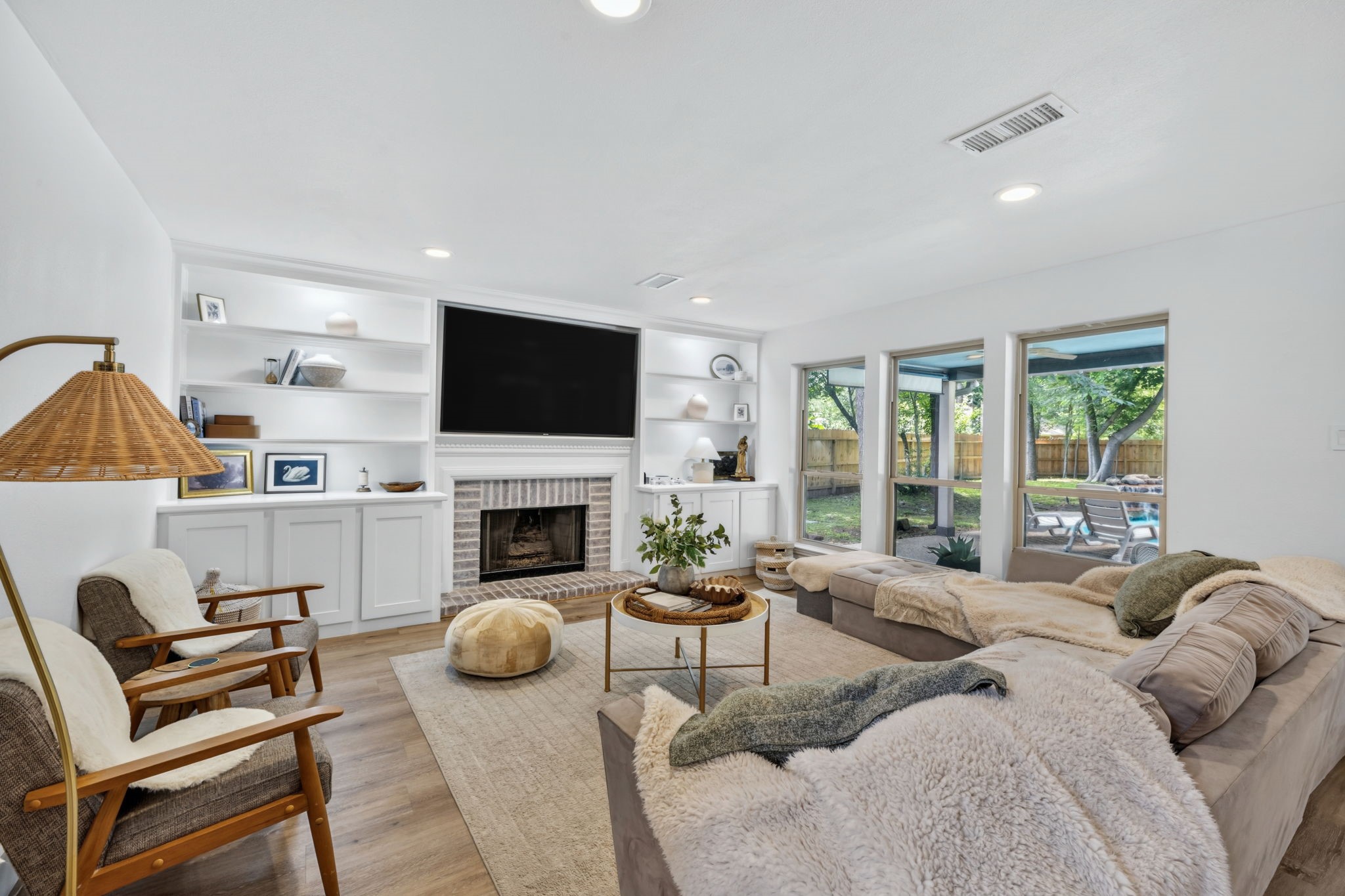 Built-ins, fireplace warmth, and walls of windows create a cozy place to gather