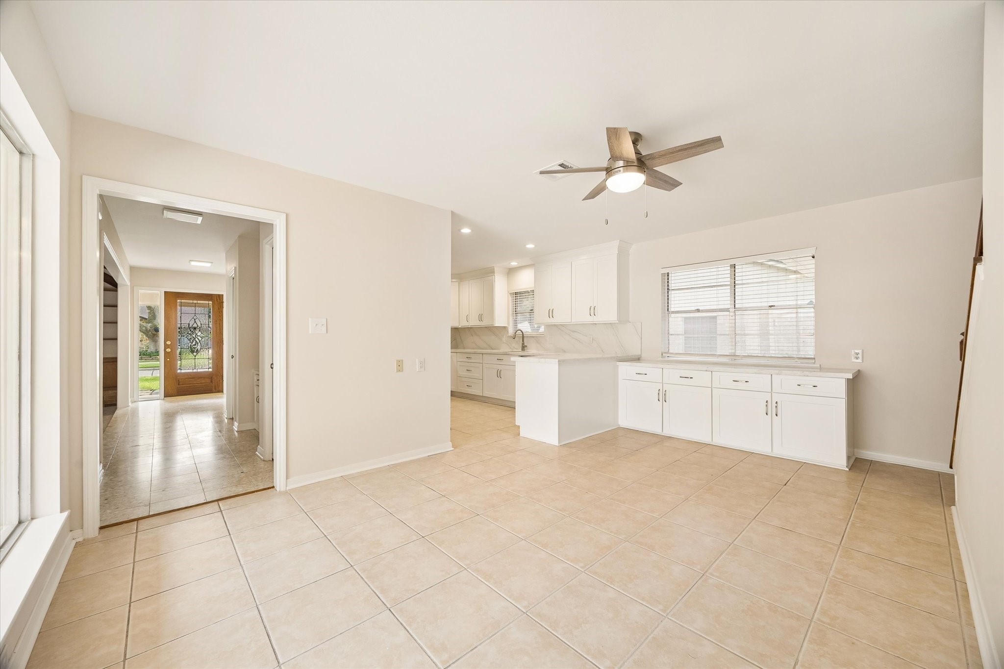 THE SPACIOUS BREAKFAST AREA FLOWS DIRECTLY INTO THE UPDATED KITCHEN AND FEATURES TILE FLOORING, A CEILING FAN, AND ABUNDANT NATURAL LIGHT.