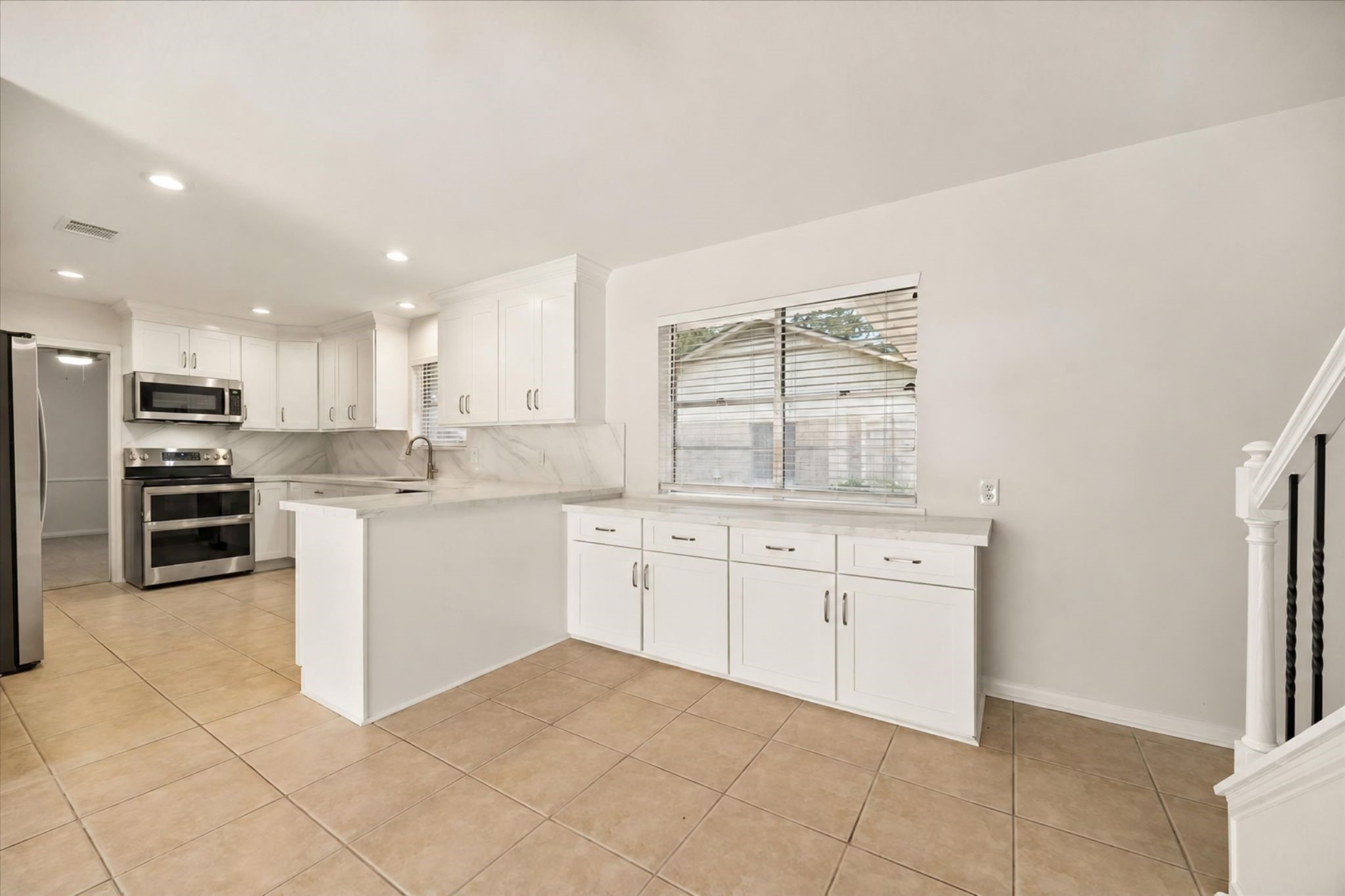 THE UPDATED KITCHEN FEATURES WHITE CABINETRY, GENEROUS STORAGE, EXTENDED COUNTER SPACE, RECESSED LIGHTING, AND A CONVENIENT BREAKFAST BAR. THE UPDATED KITCHEN FEATURES WHITE CABINETRY, GENEROUS STORAGE, EXTENDED COUNTER SPACE, RECESSED LIGHTING, AND A CONVENIENT BREAKFAST BAR.