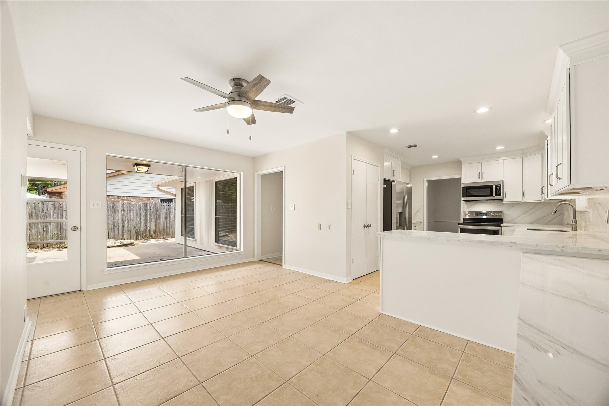THIS OPEN BREAKFAST AREA OFFERS EASY ACCESS TO THE KITCHEN AND BACK PATIO, WITH LARGE WINDOWS BRINGING IN PLENTY OF NATURAL LIGHT.