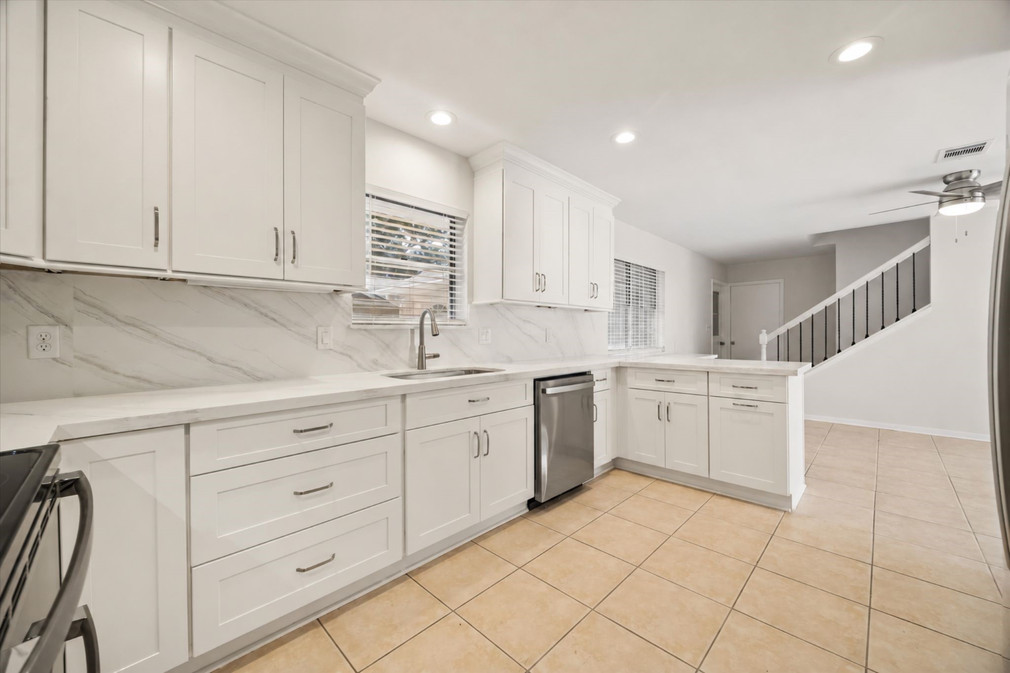 THE UPDATED KITCHEN OFFERS ABUNDANT WHITE CABINETRY, STONE COUNTERTOPS, A FULL-HEIGHT BACKSPLASH, STAINLESS STEEL APPLIANCES, AND RECESSED LIGHTING. THE UPDATED KITCHEN OFFERS ABUNDANT WHITE CABINETRY, STONE COUNTERTOPS, A FULL-HEIGHT BACKSPLASH, STAINLESS STEEL APPLIANCES, AND RECESSED LIGHTING.