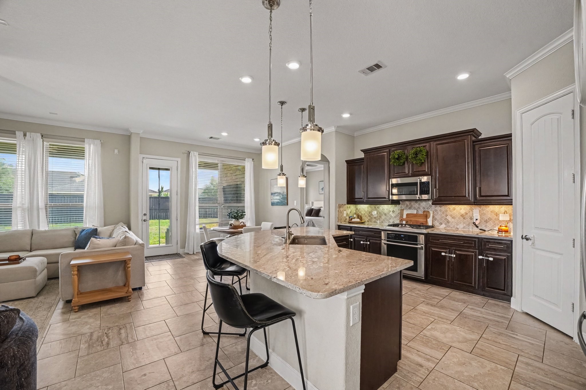 This open-concept gourmet kitchen serves as the ideal gathering spot, blending functional modern living with rich architectural finishes.