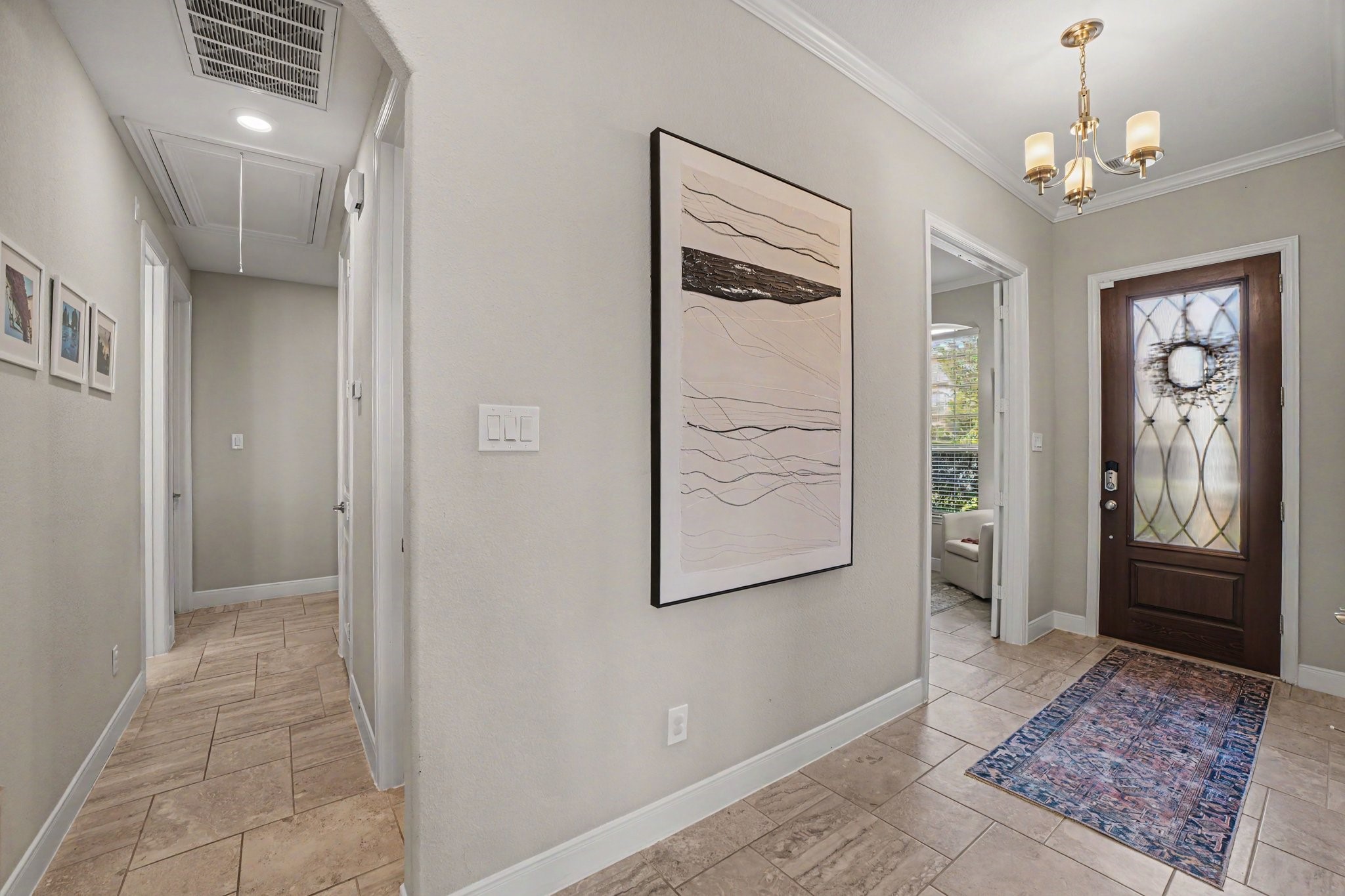 Step inside and feel immediately at home in this warm, inviting foyer that sets a gracious tone for the rest of this beautiful residence. As you pass through the ornate, glass-paneled wood front dooradorned with a welcoming decorative wreathyou are greeted by an abundance of natural light and a sense of open, airy comfort.