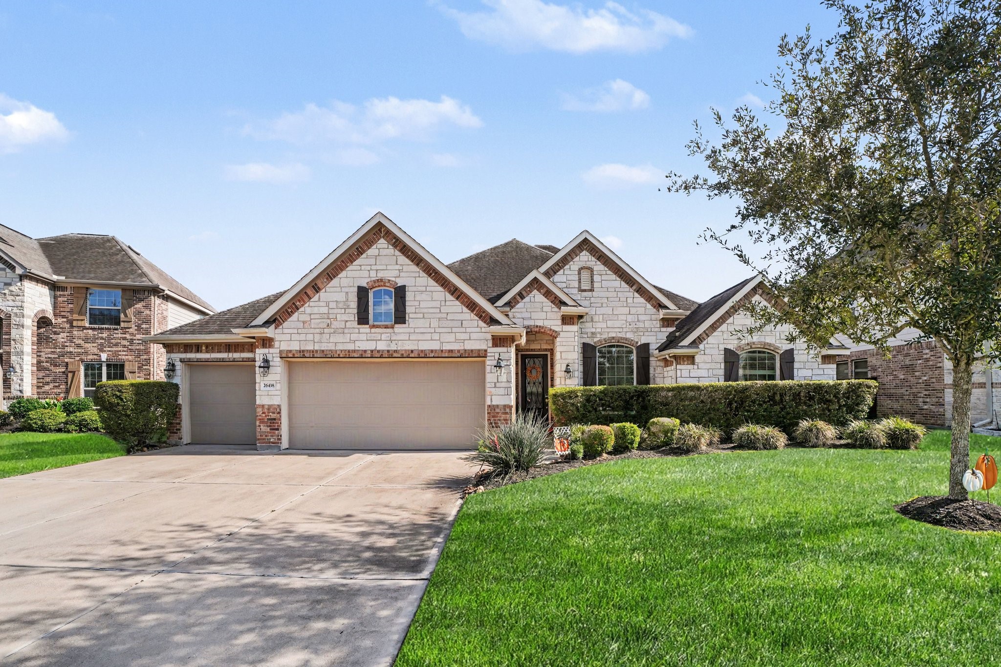 Arched windows, accent stonework, classic lantern exterior lighting, and textured shingle roofing give this home an elegant, craftsman-inspired aesthetic. Arched windows, accent stonework, classic lantern exterior lighting, and textured shingle roofing give this home an elegant, craftsman-inspired aesthetic.
