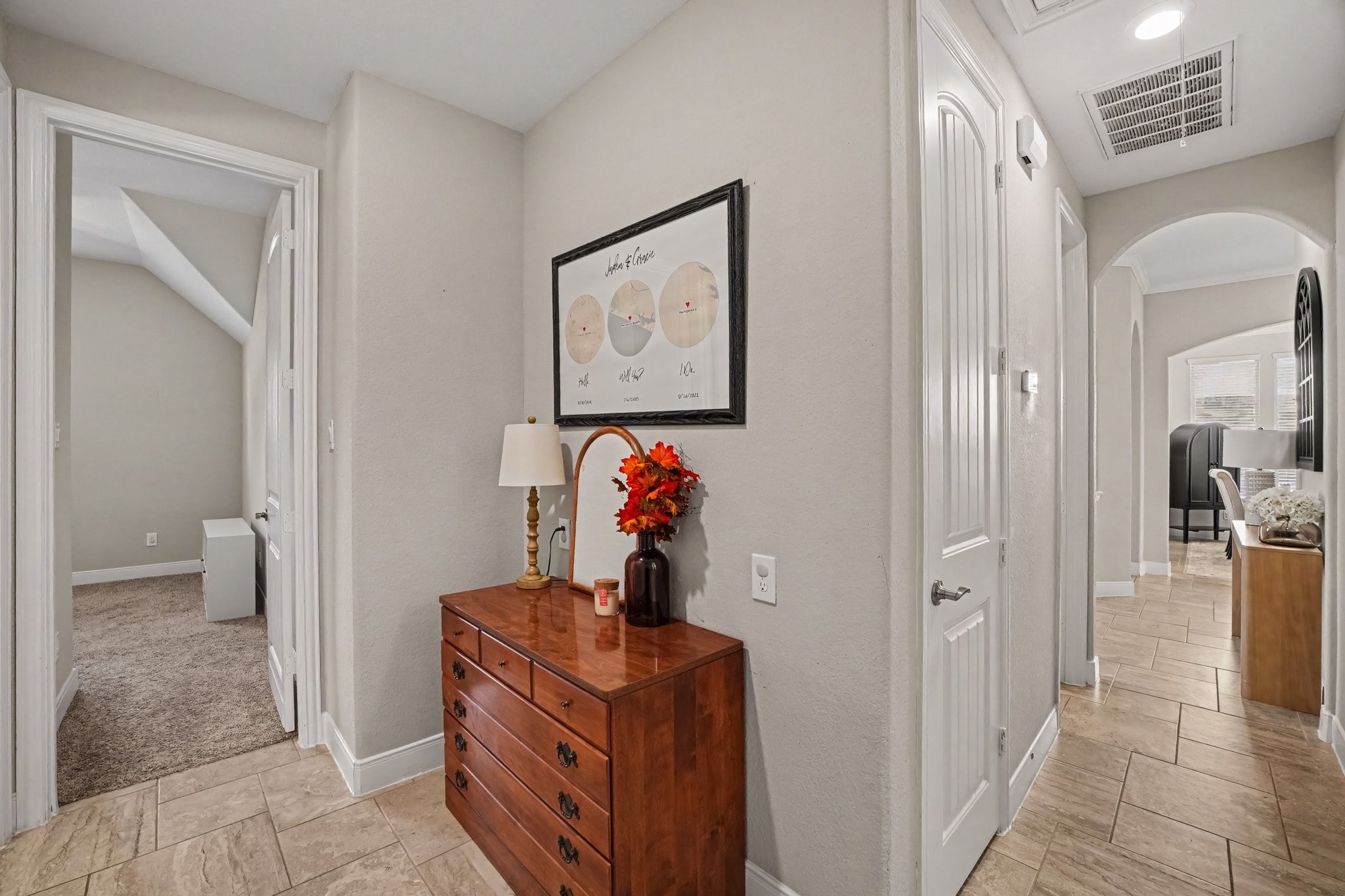 This central hallway hub demonstrates the functional, well-designed split-floor plan of the home. Modern neutral paint, crisp white trim, and continuous tile flooring tie the corridors together, creating a clean, cohesive transition between living areas and private quarters.