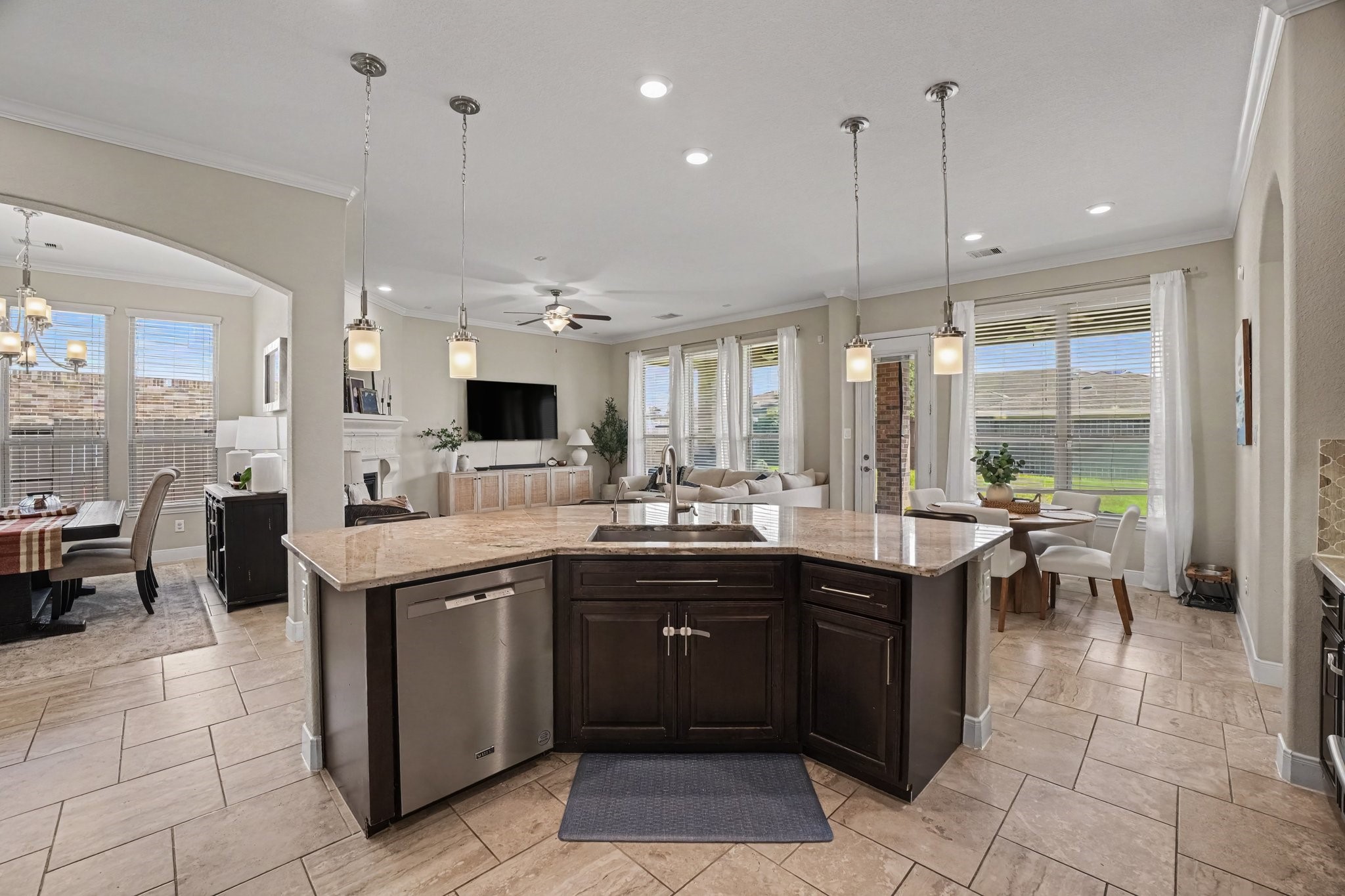 The open design flows effortlessly into the formal dining room through an elegant arched opening, as well as into the main living room, keeping everyone connected whether cooking, dining, or entertaining guests.