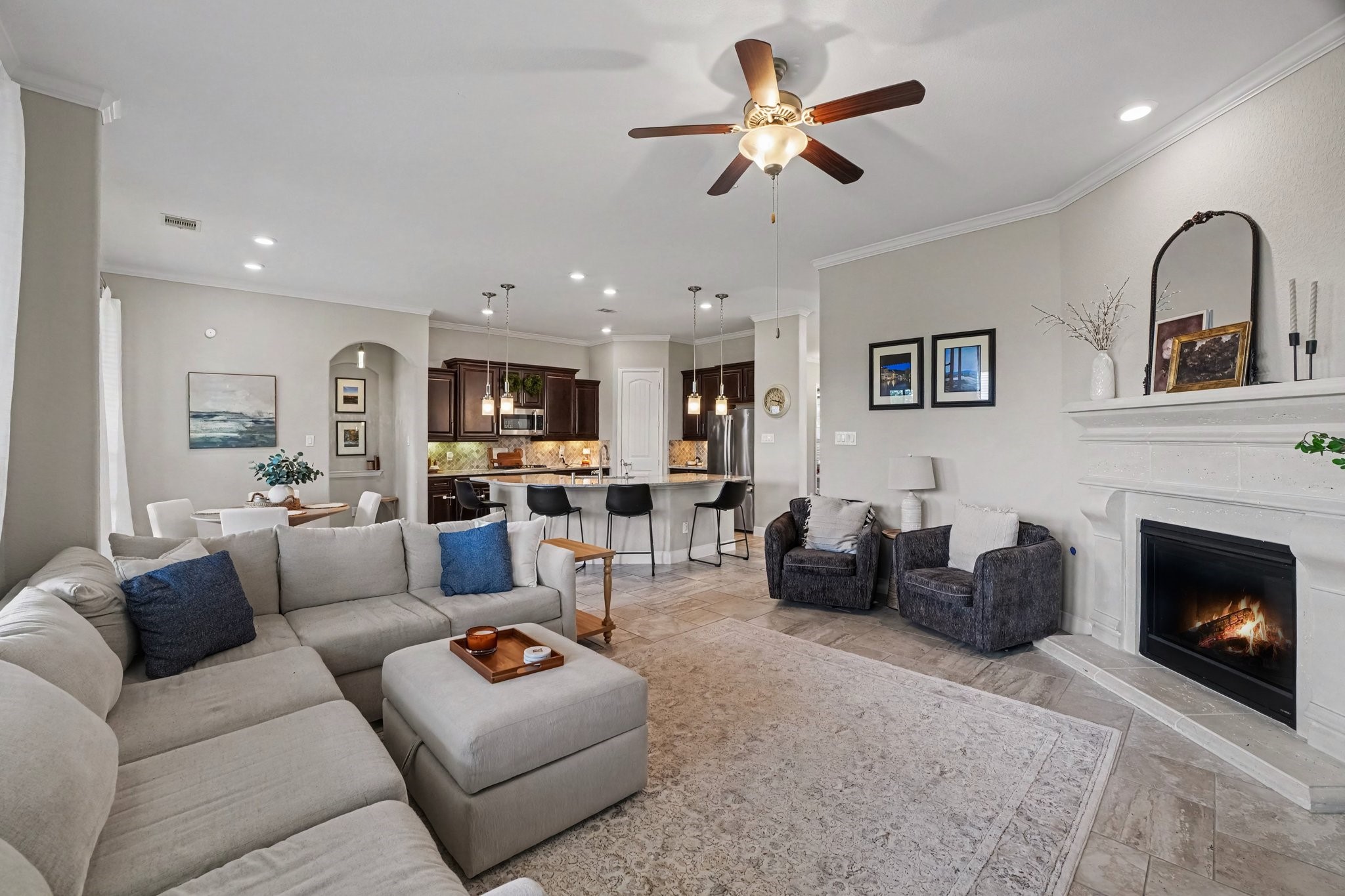 A classic, grand mantel and cozy fireplace create an elegant focal point for intimate gatherings or relaxing evenings. This living room opens to the kitchen!