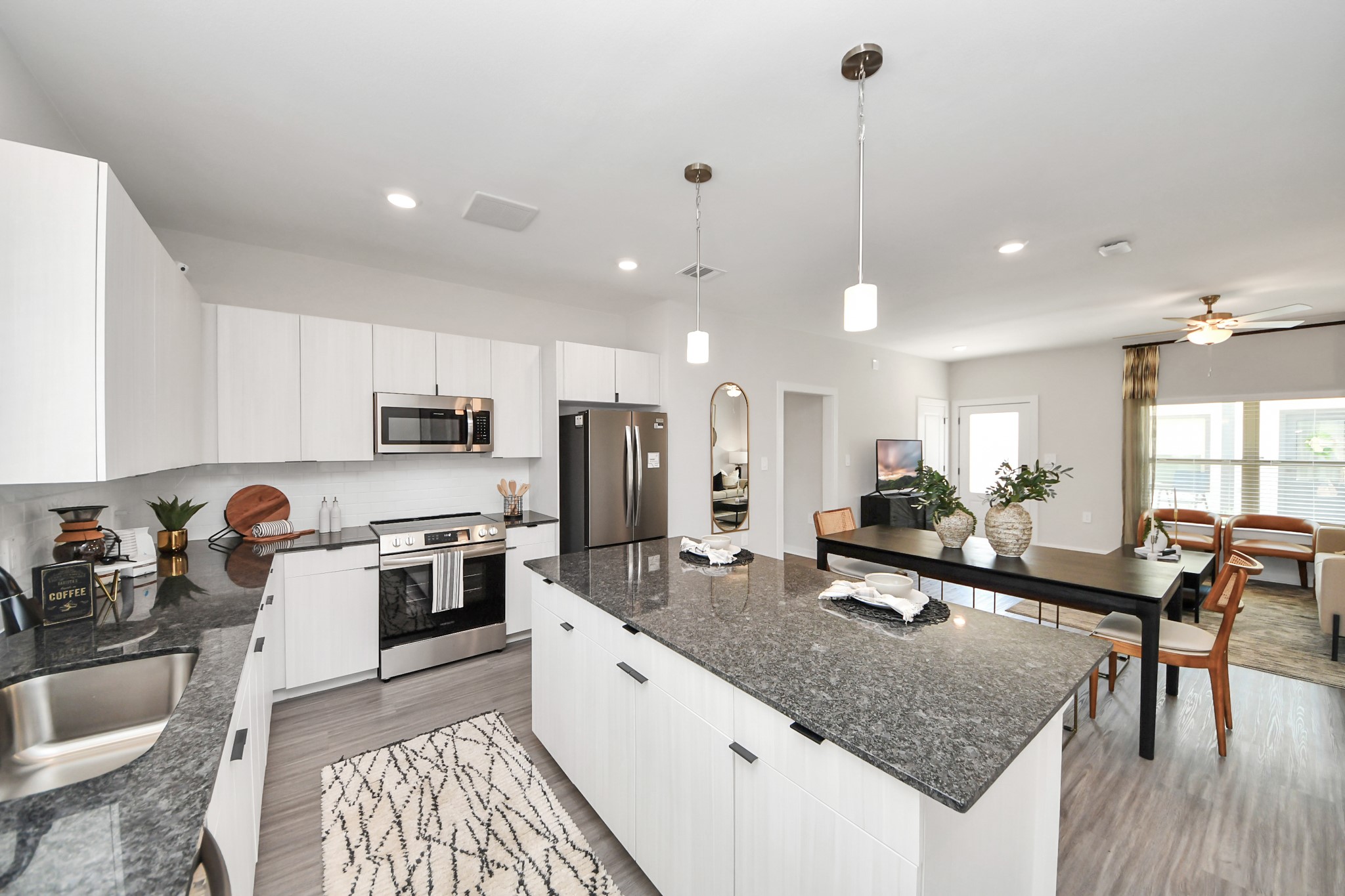 Boasting luxury finishes-stylish Island kitchen,granite counters,subway tile backsplash,ample custom cabinet space,stainless appliances,refrigerator,full size washer&dryer included,wood-like flooring throughout,open concept floor plan.