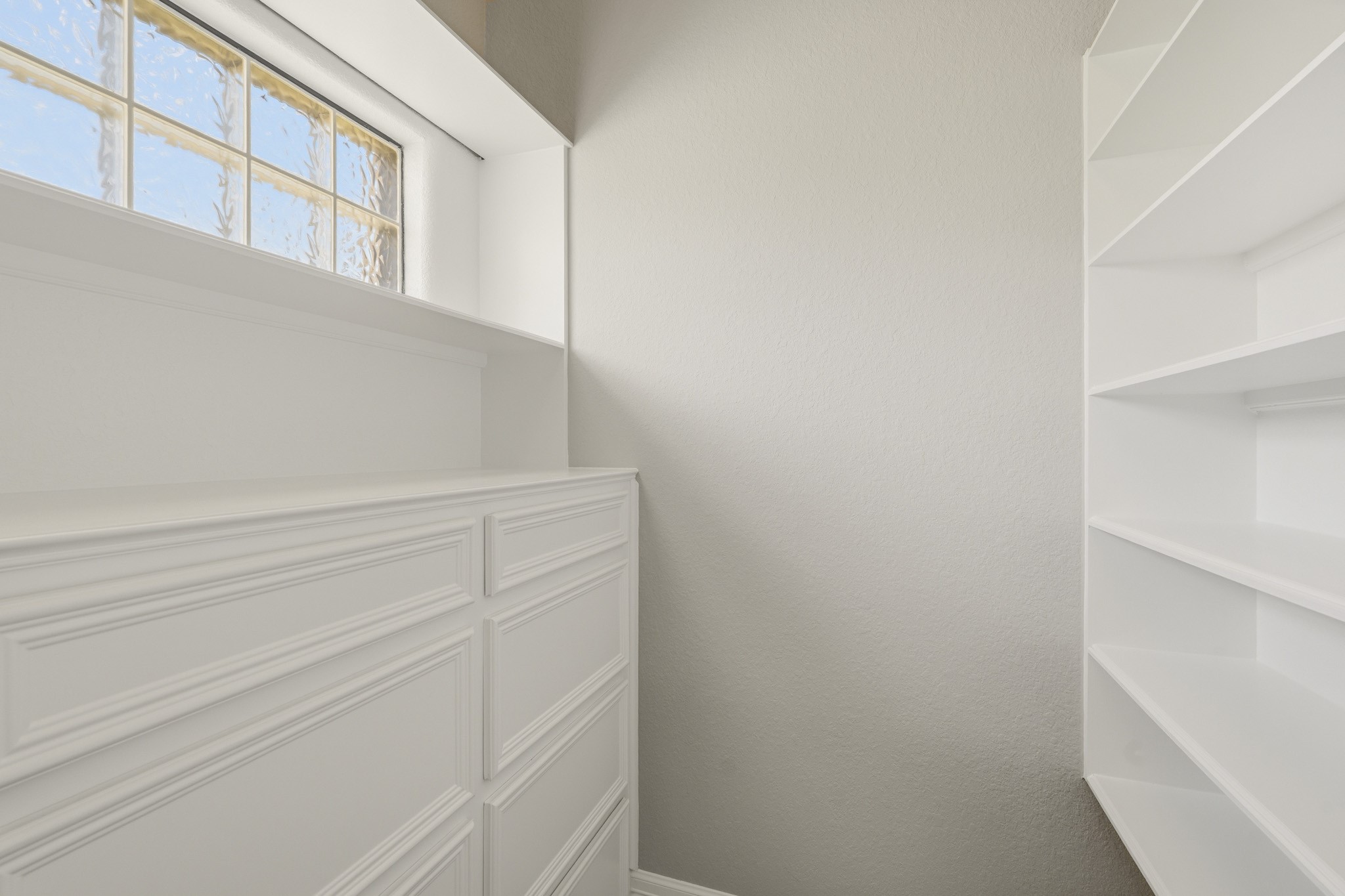 Generous walk-in closet with extensive built-in storage