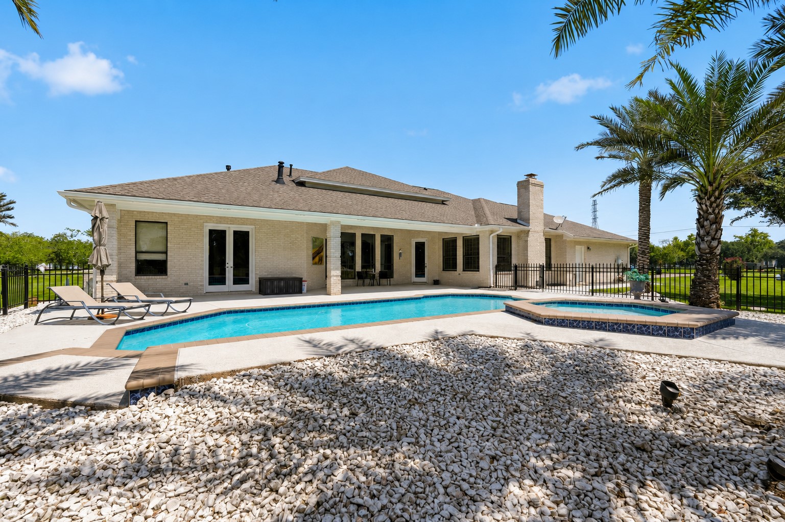 Rear view of the home, pool, spa and covered patio