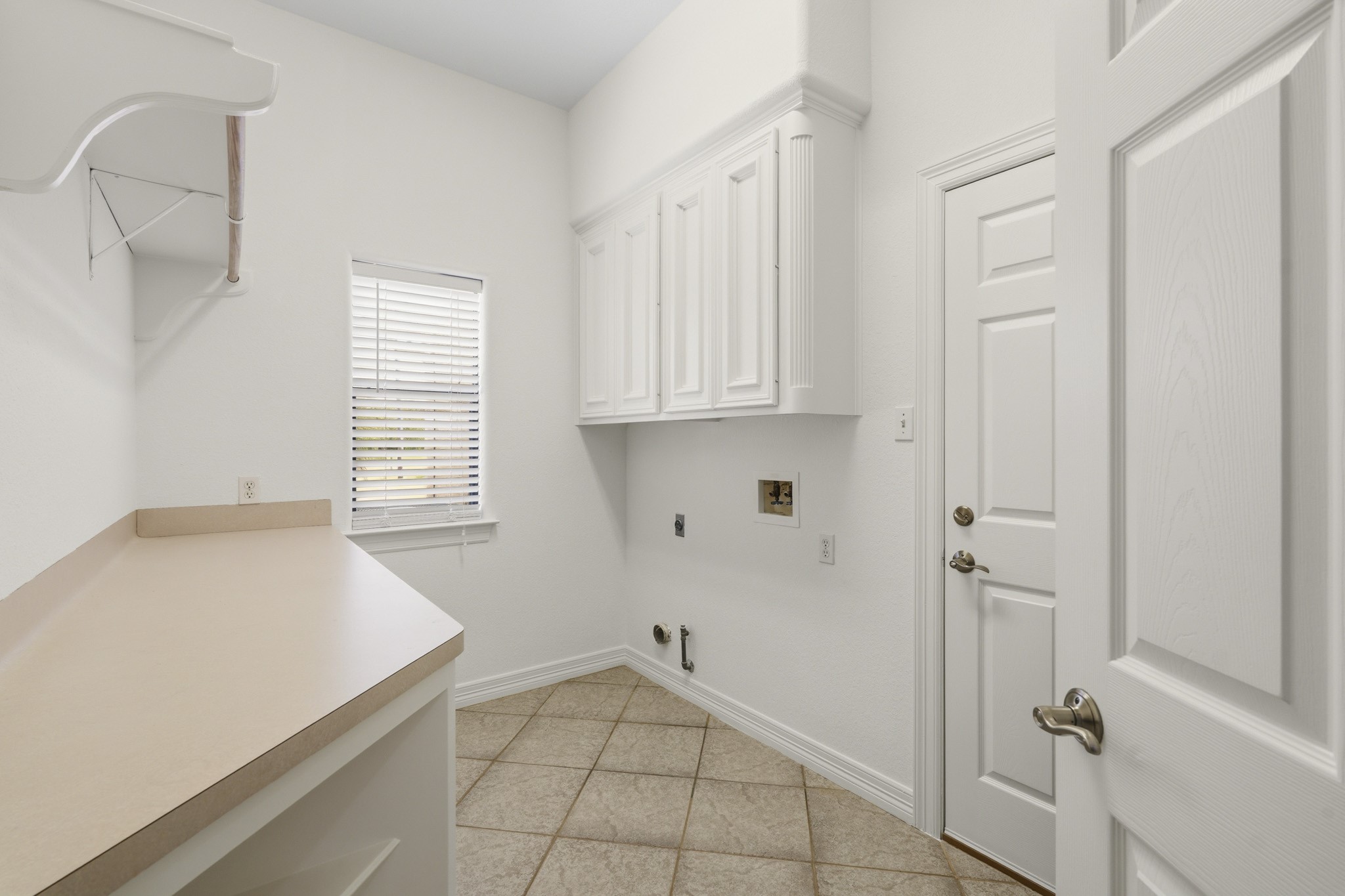 Dedicated laundry room with built-in cabinetry and utility sink