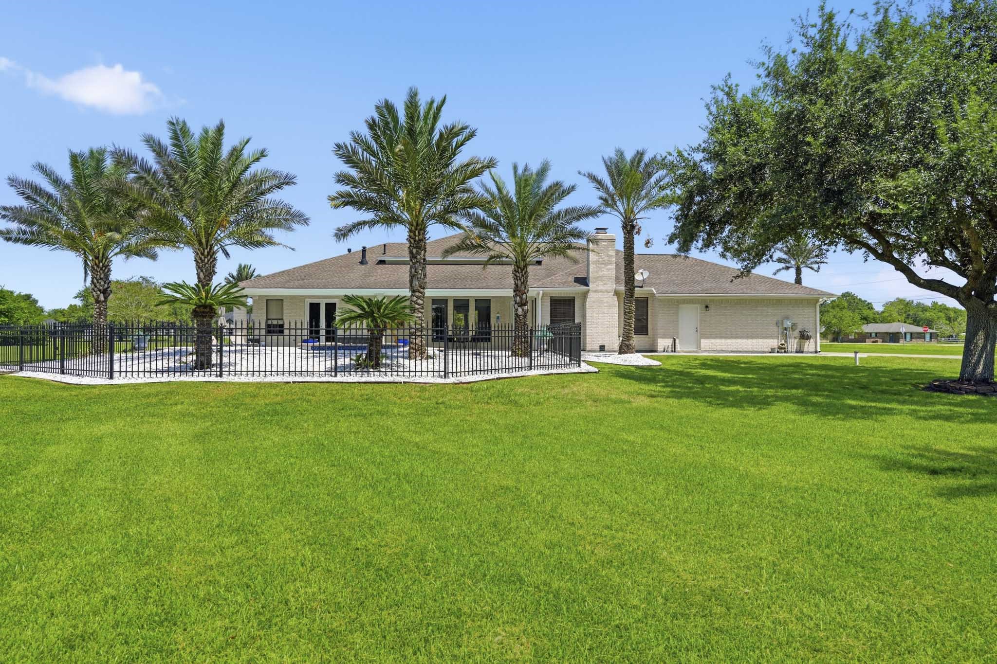Rear exterior surrounded by mature trees and tropical landscaping
