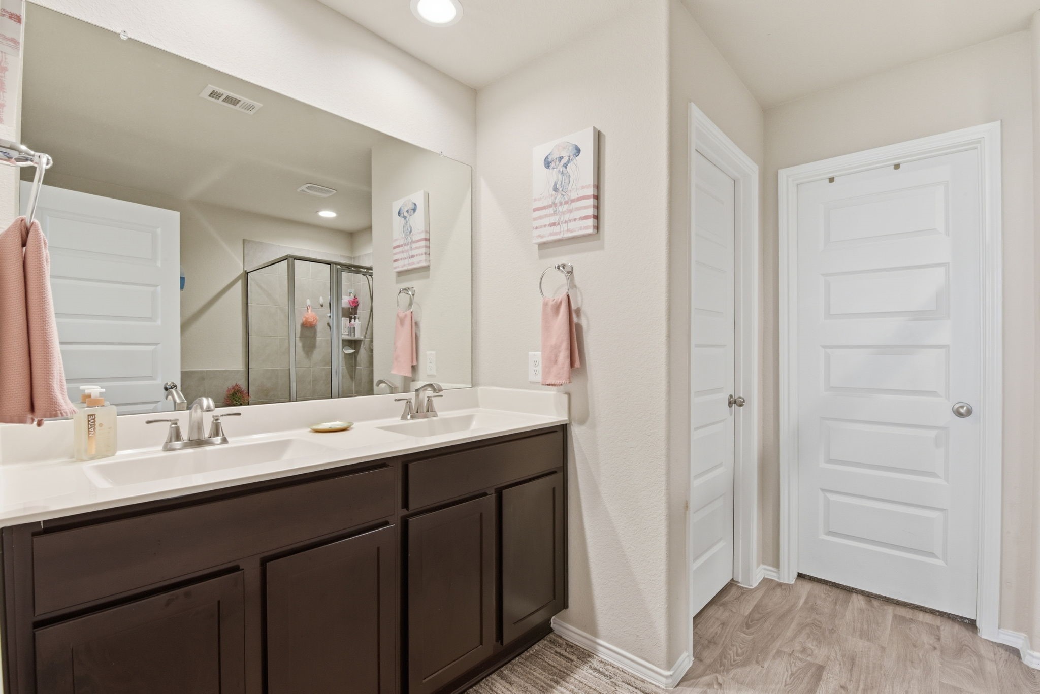 Luxurious primary bathroom with double sinks and large vanity.