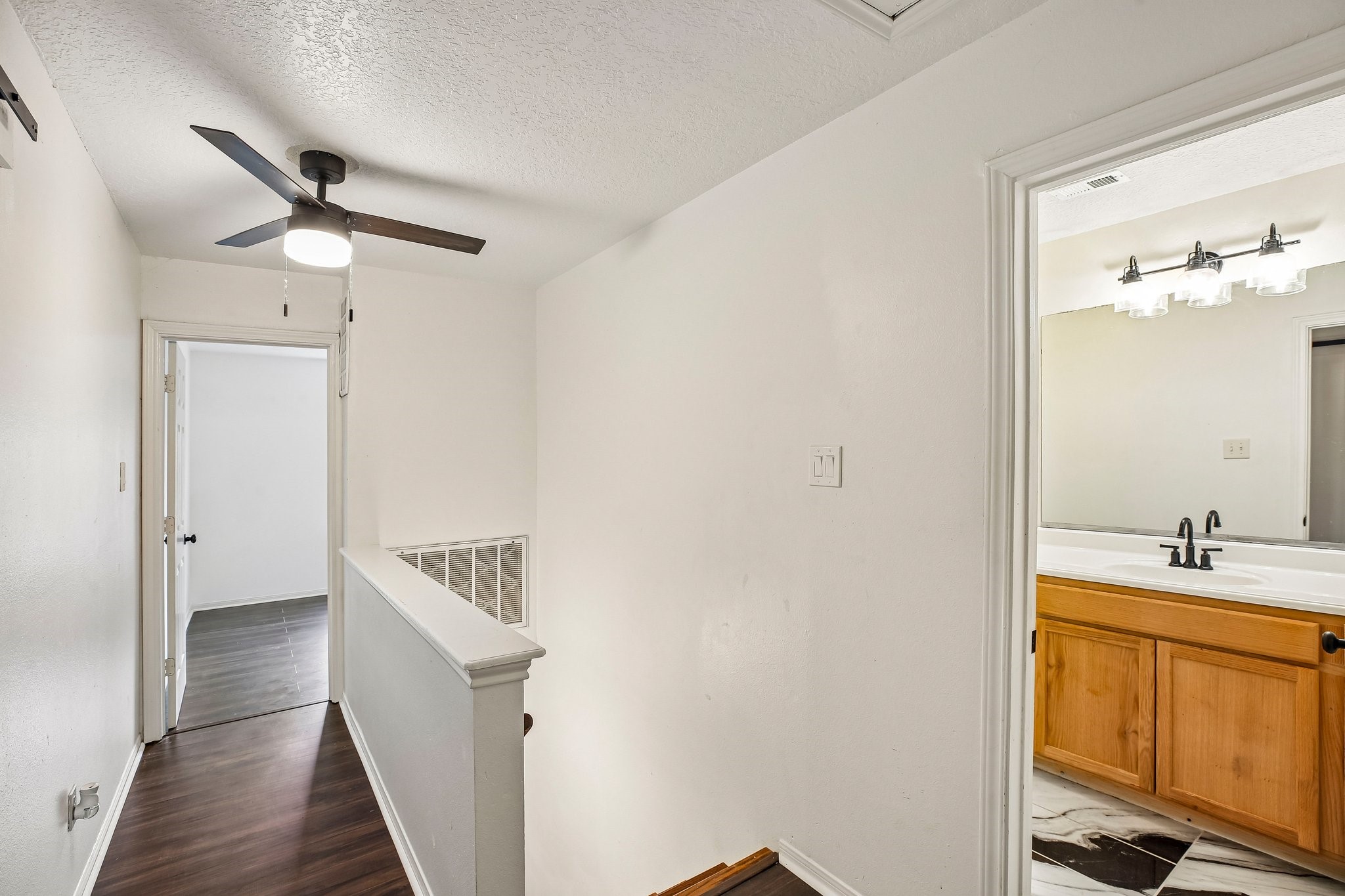 The second floor features two additional bedrooms, a full bathroom with marble flooring, and a large storage closet that was previously used as a craft room.