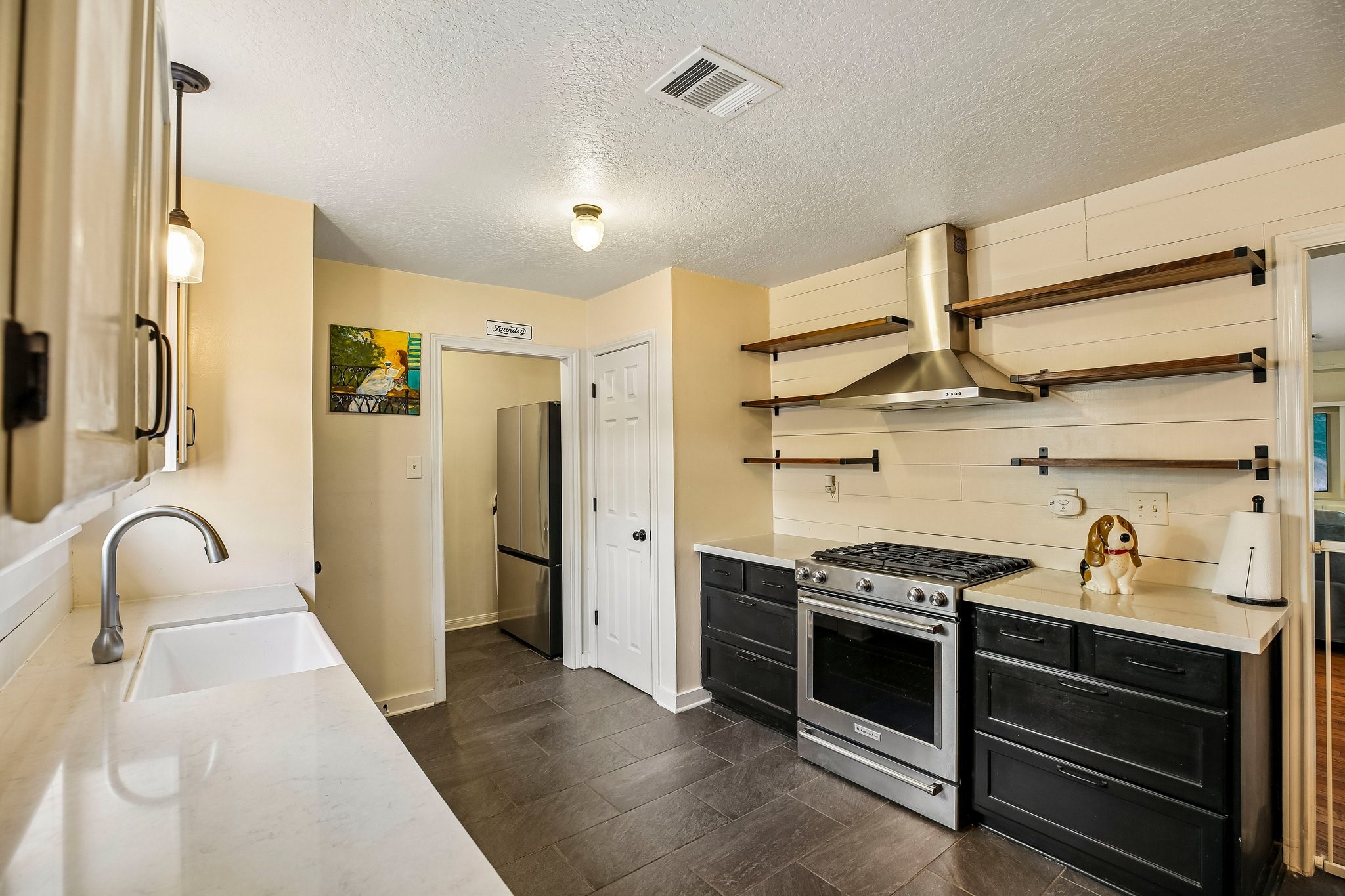 The kitchen features a stainless steel KitchenAid gas oven and range.