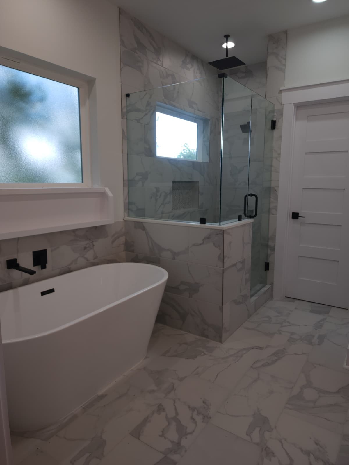 Indulge in relaxation with a stand-alone tub featuring a candle shelf, complemented by a separate shower with frameless glass and a soothing rain showerhead.