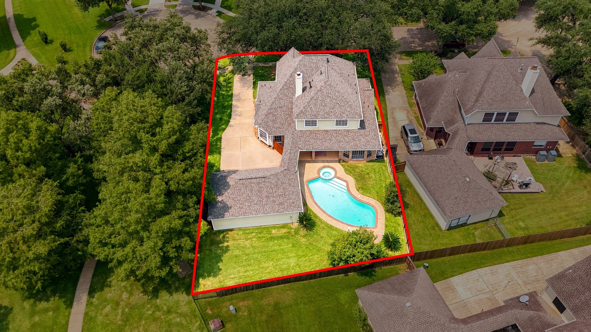 Discover a spacious two-story home featuring a uniquely shaped pool in a private, fenced backyard, all surrounded by lush greenery for a serene and secluded retreat.