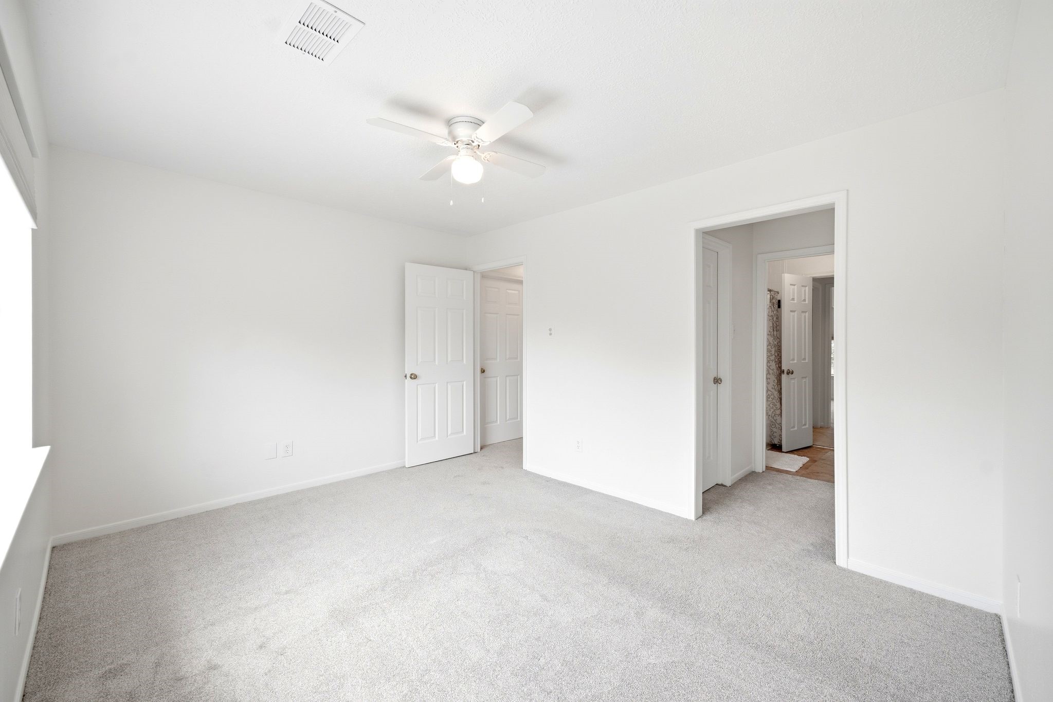 Bright and inviting, the third bedroom offers a blank canvas with plush carpeting and ample natural light, ready for your personal touch.