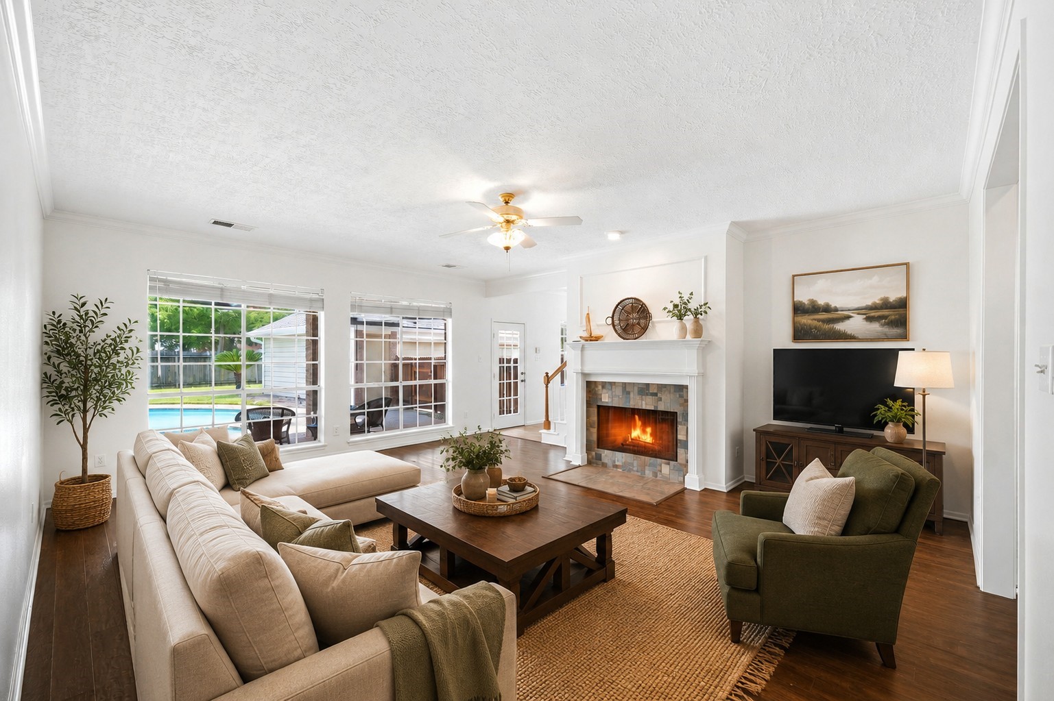 The living room offers a cozy fireplace, abundant natural light from large windows, and a stunning view of the backyard pool, creating a perfect blend of comfort and style.