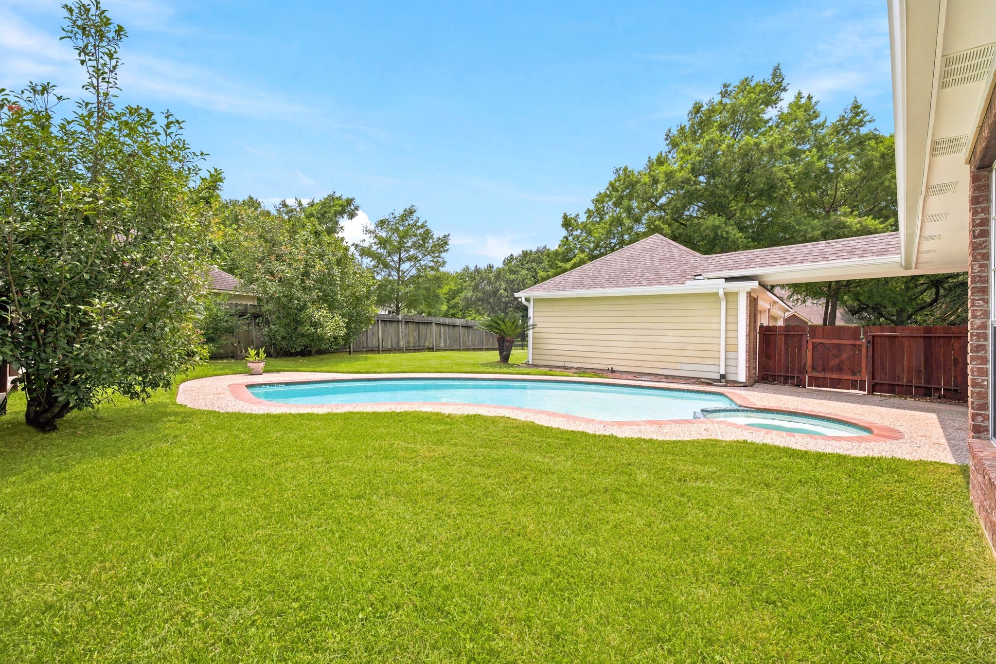 Discover your private oasis with a sparkling pool, lush lawn, and mature trees, all enclosed by a charming wooden fenceperfect for relaxation and outdoor fun.