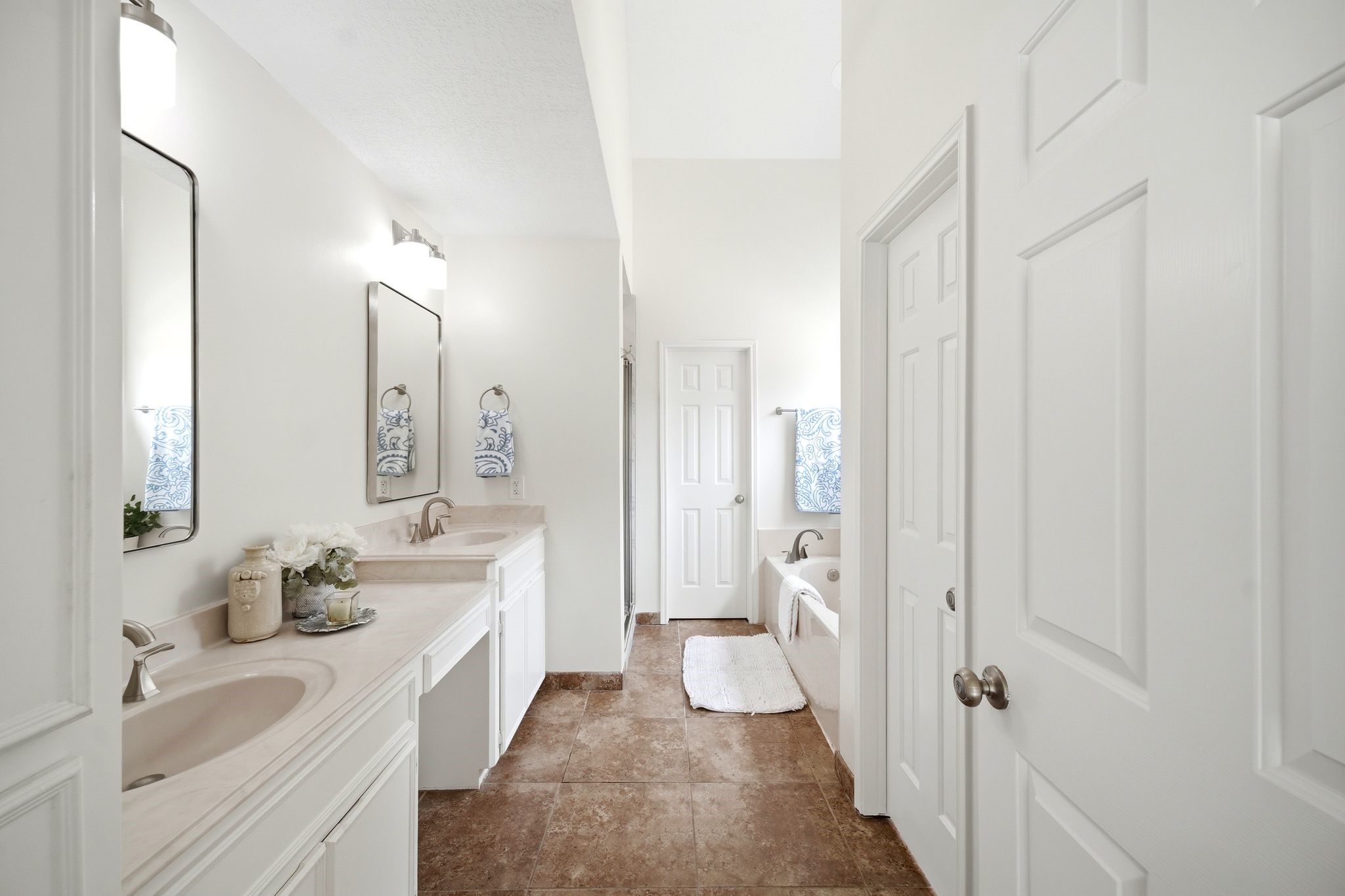 Discover a spacious and inviting bathroom featuring a double vanity with elegant fixtures, enhanced by a large mirror and serene neutral tones.