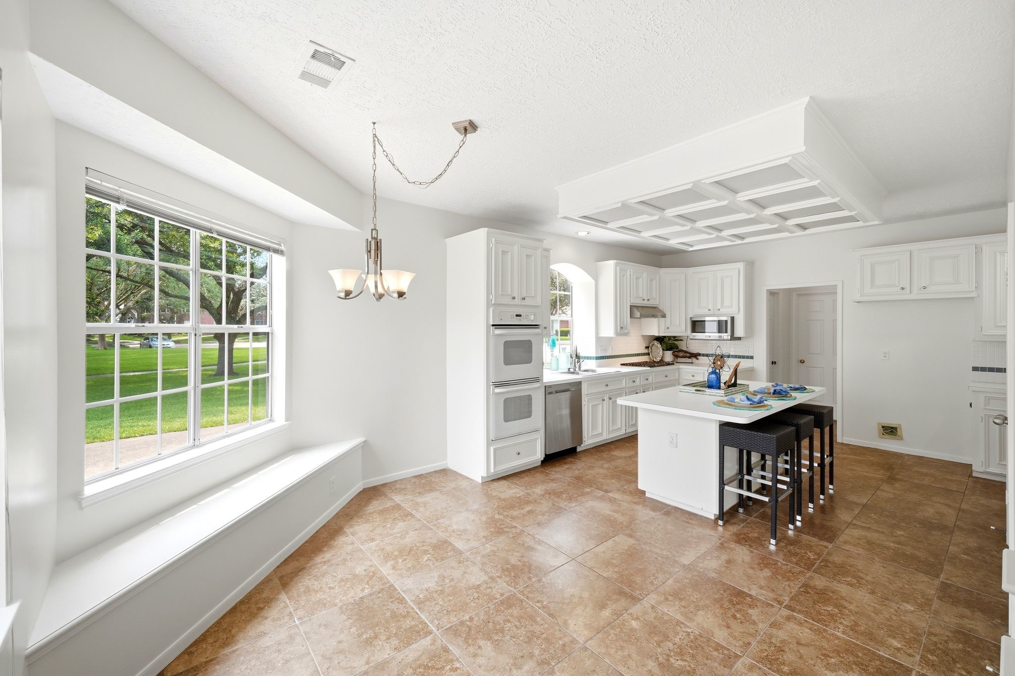 Flooded with natural light, this inviting breakfast room features a spacious window seat and seamlessly connects to a modern kitchen, perfect for morning gatherings.