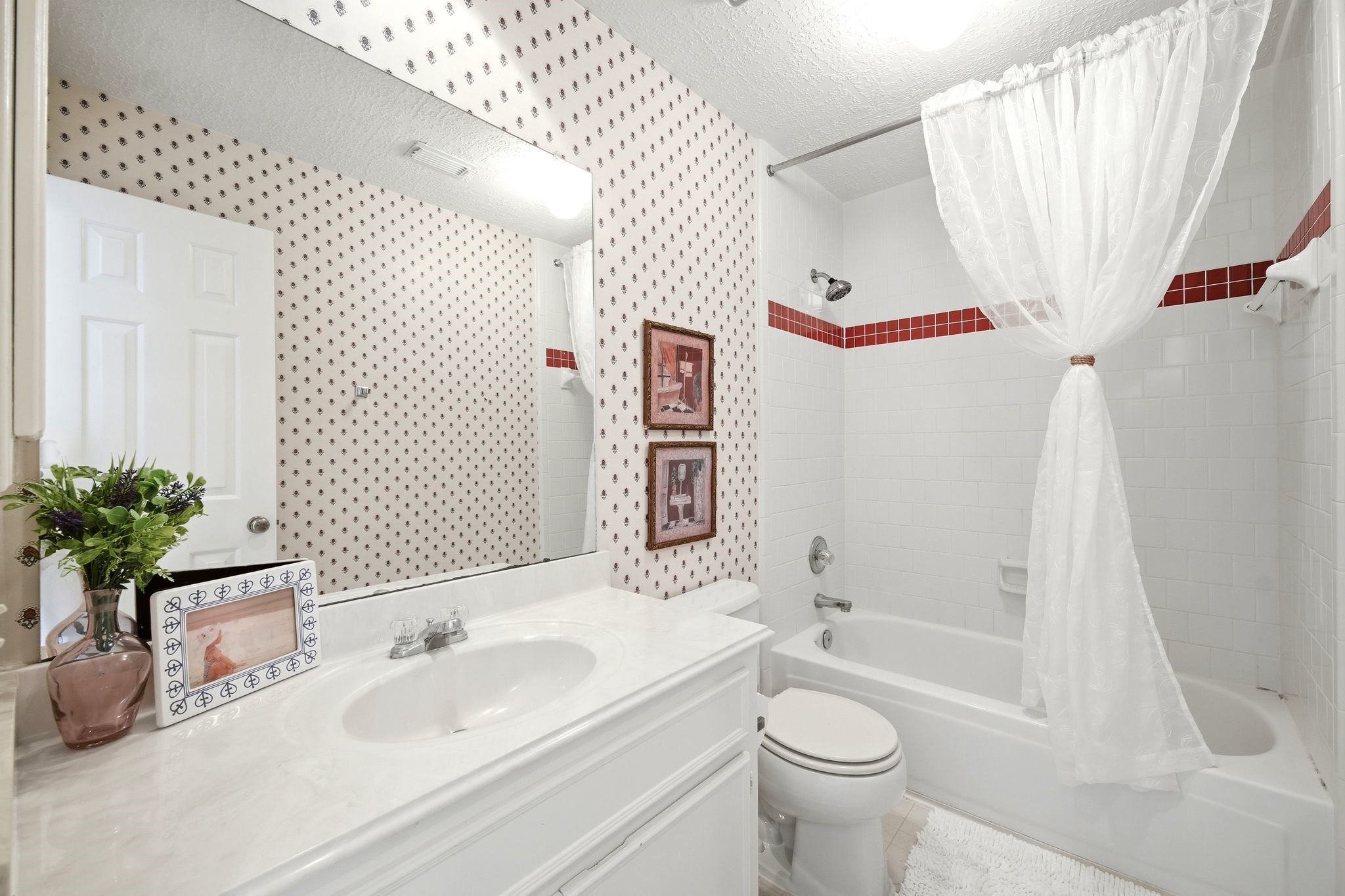 Upstairs, the second bathroom offers a charming tub/shower combo, accented by a bright and inviting design that ensures relaxation and convenience.