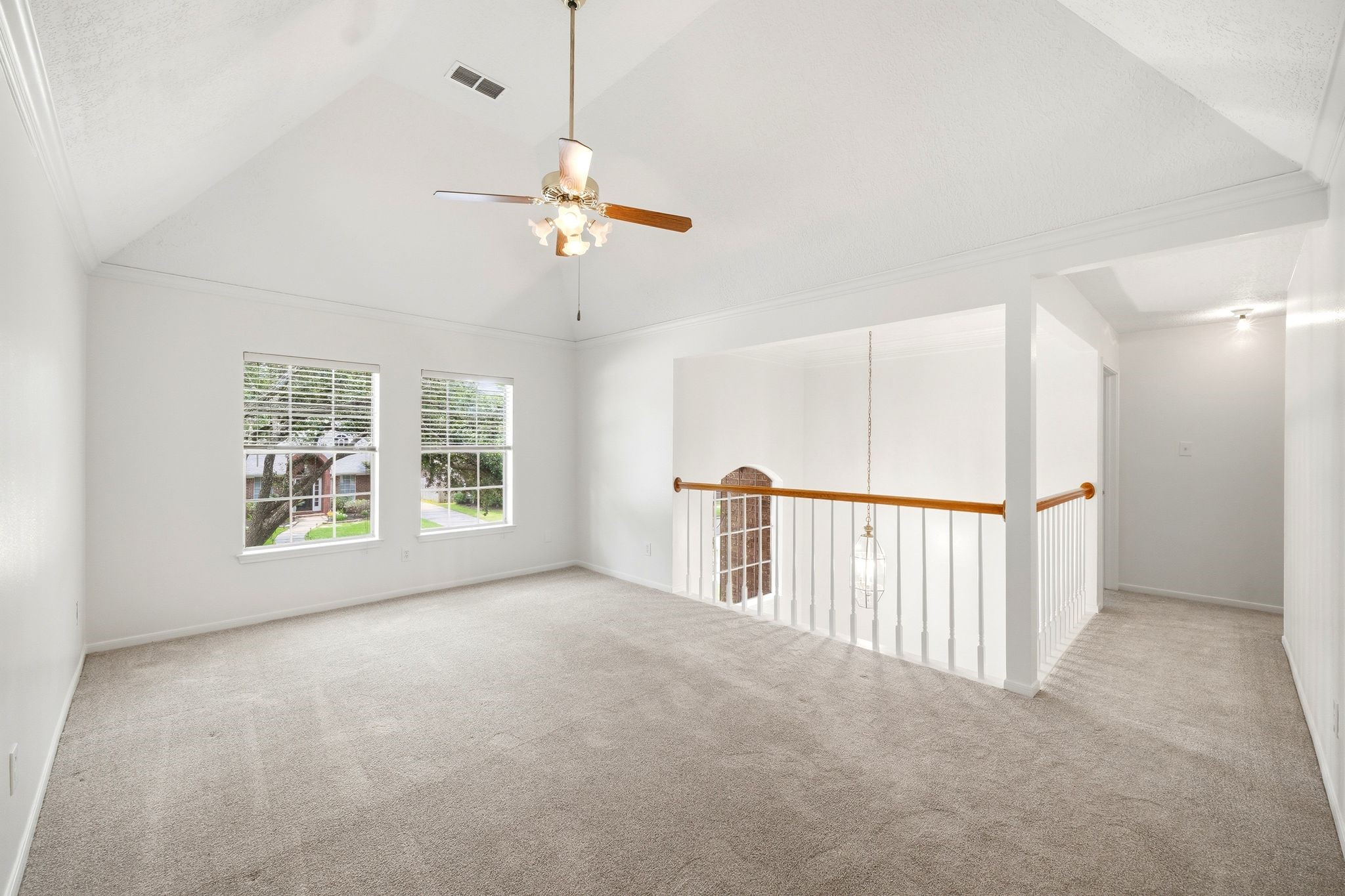 The gameroom, overlooking a stairway with an elegant railing, offers a versatile space perfect for a living area or loft.