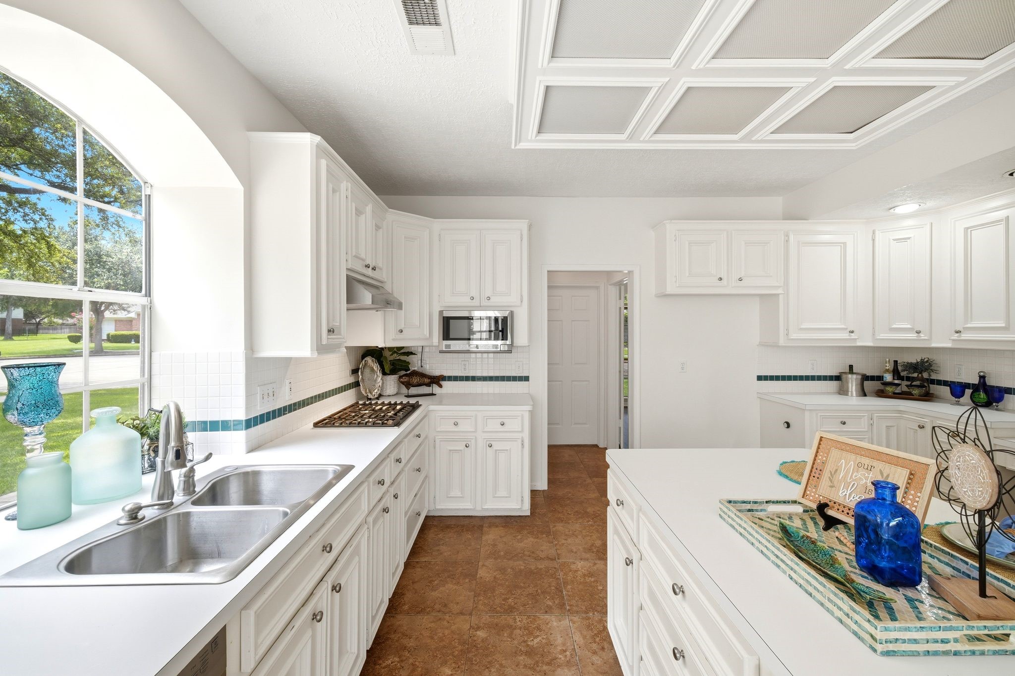 Experience the perfect blend of functionality and style in this kitchen with double sinks, ample counter space, abundant storage, a cozy desk area, and a delightful coffee bar.