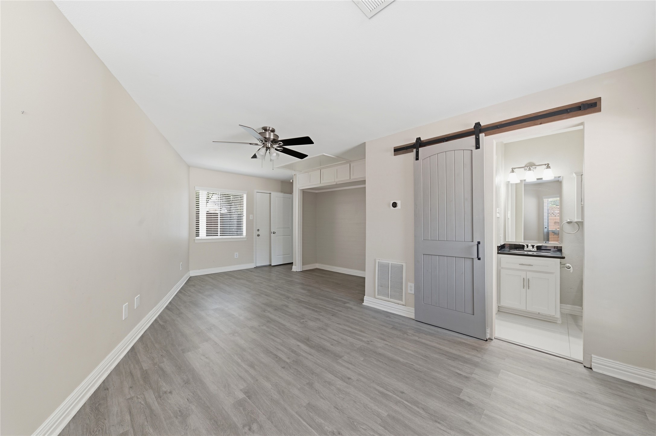 Additional full bathroom showcasing a stylish sliding barn door.