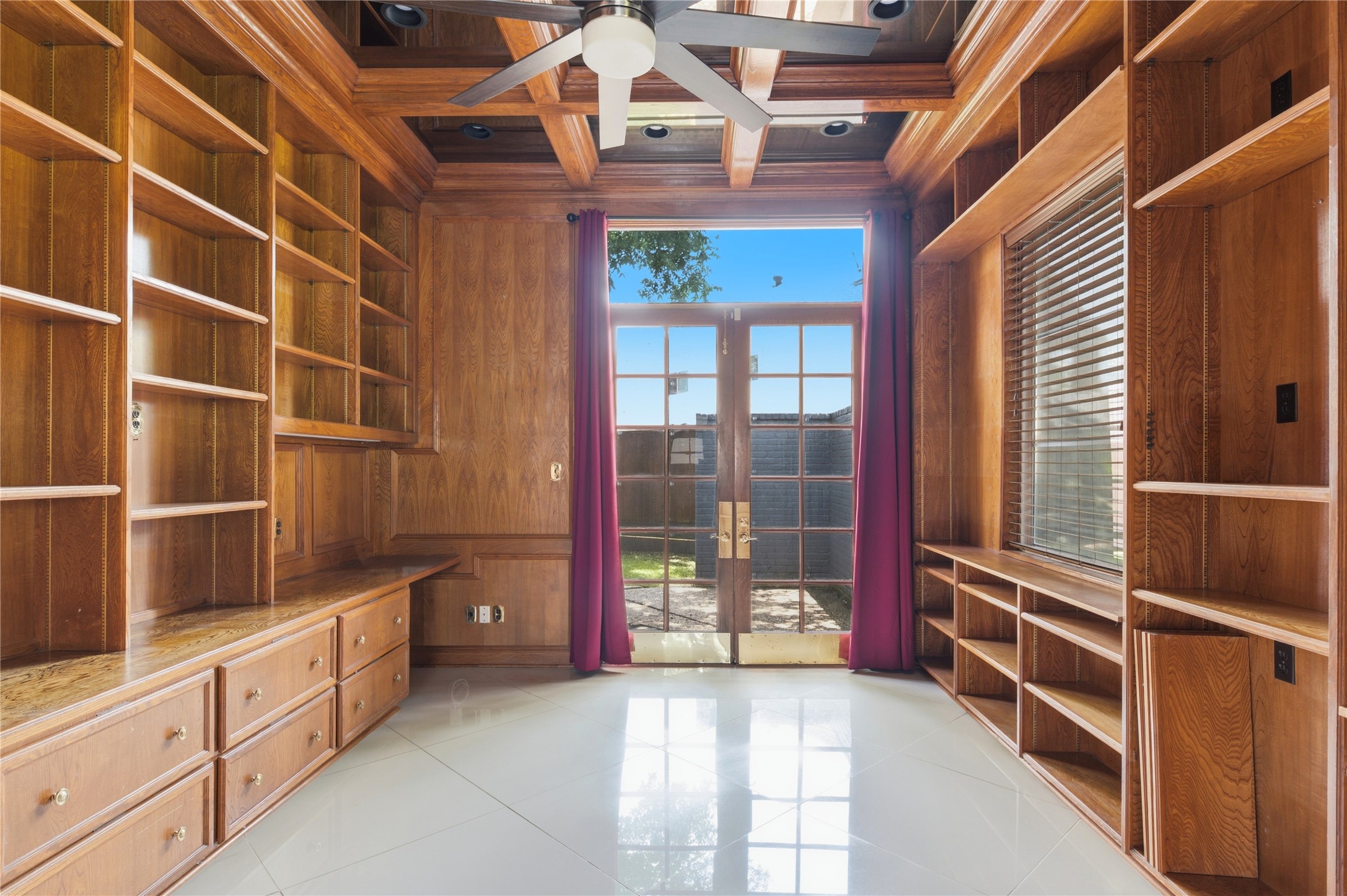 Dedicated home office featuring extensive built-in shelving and classic French doors.