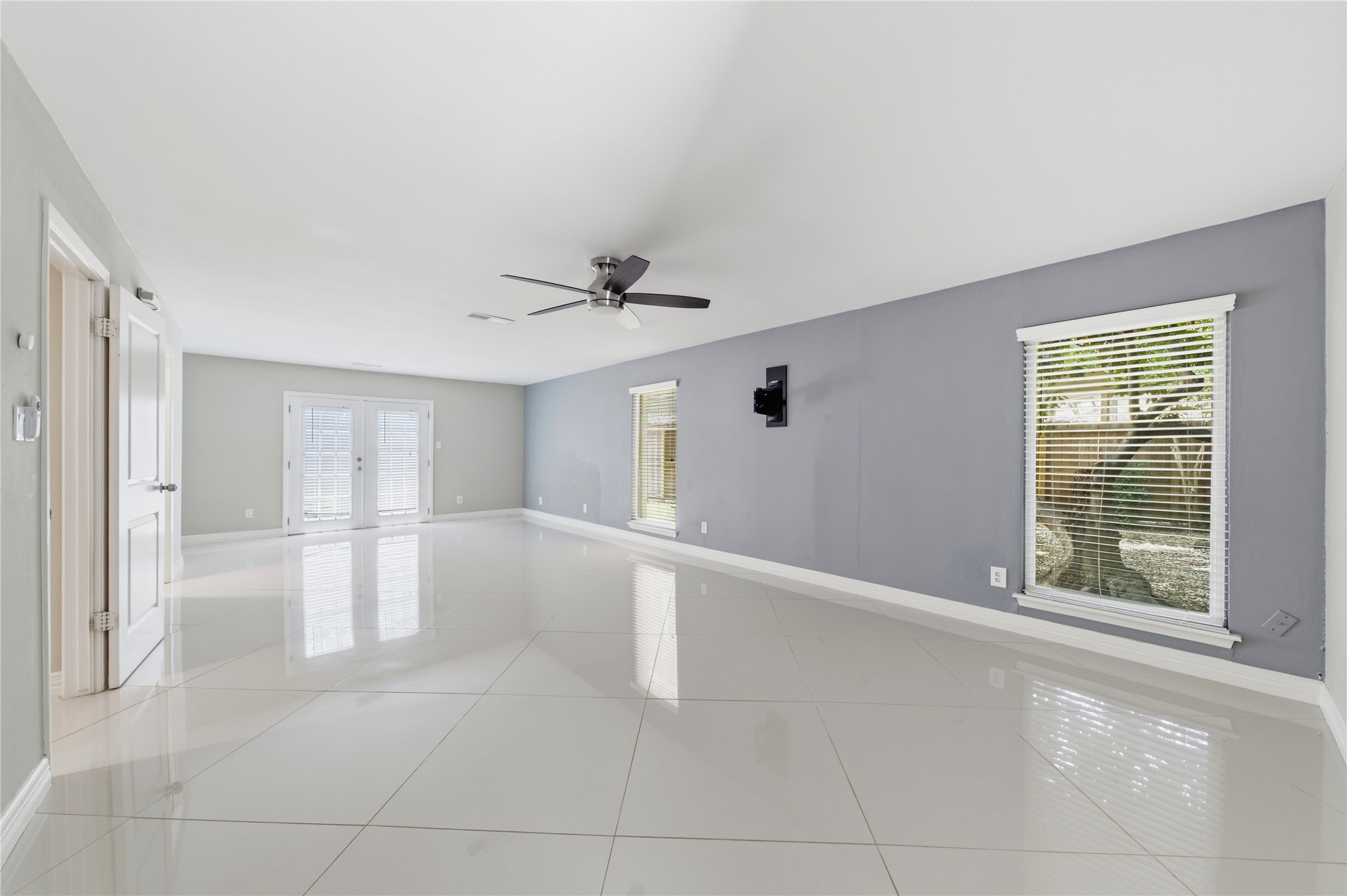 Expansive primary bedroom with pristine, carpet-free flooring and bright, neutral finishes.