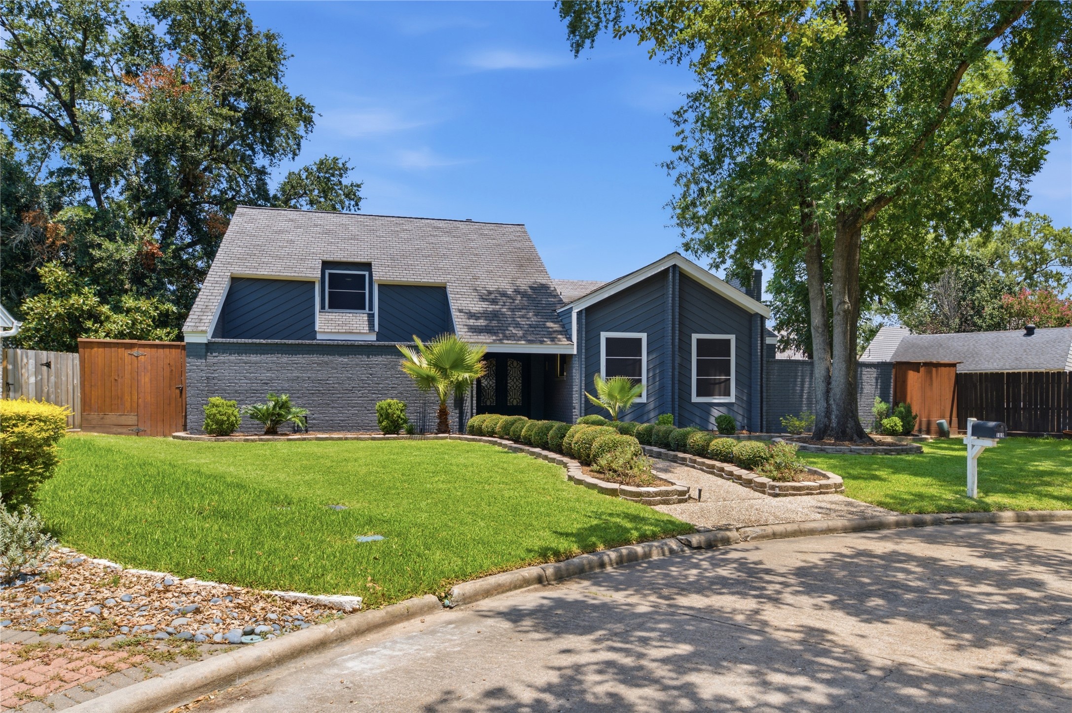 Striking mid-century modern curb appeal with mature landscaping.