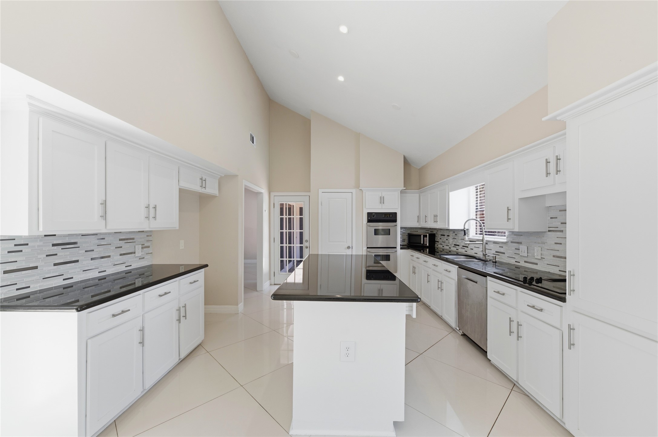 The kitchen features a generous center island perfect for prep work and entertaining, plus premium stainless steel appliances including double ovens.