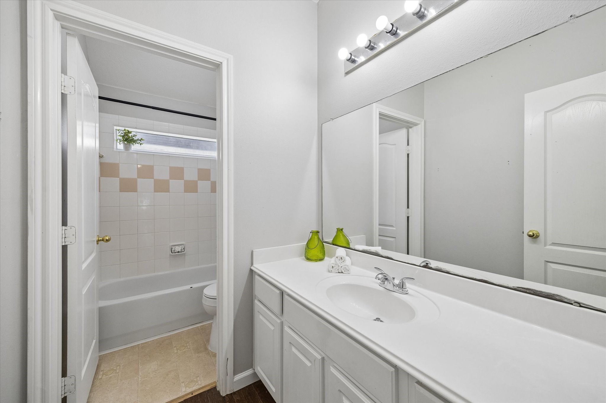 The shared guest bathroom features a separate vanity and shower area making morning prep easy!  A long countertop and vanity lets everyone have space to keep toiletries handy.
