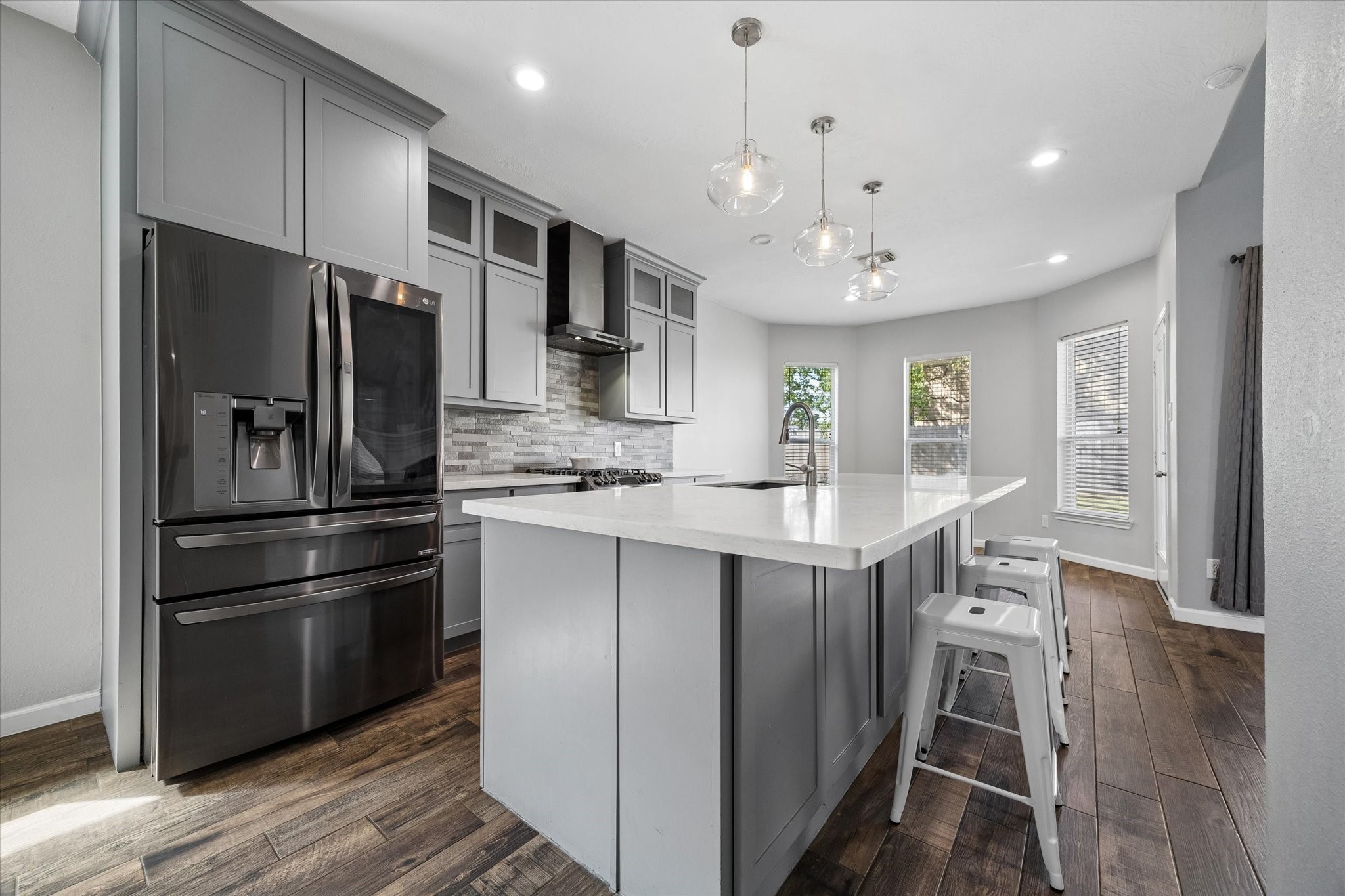 On-trend PENDANT LIGHTS hang above the island. The island is a great spot for people to gather and offers seating and storage!  Durable Quartz counters look beautiful and are low-maintenance.