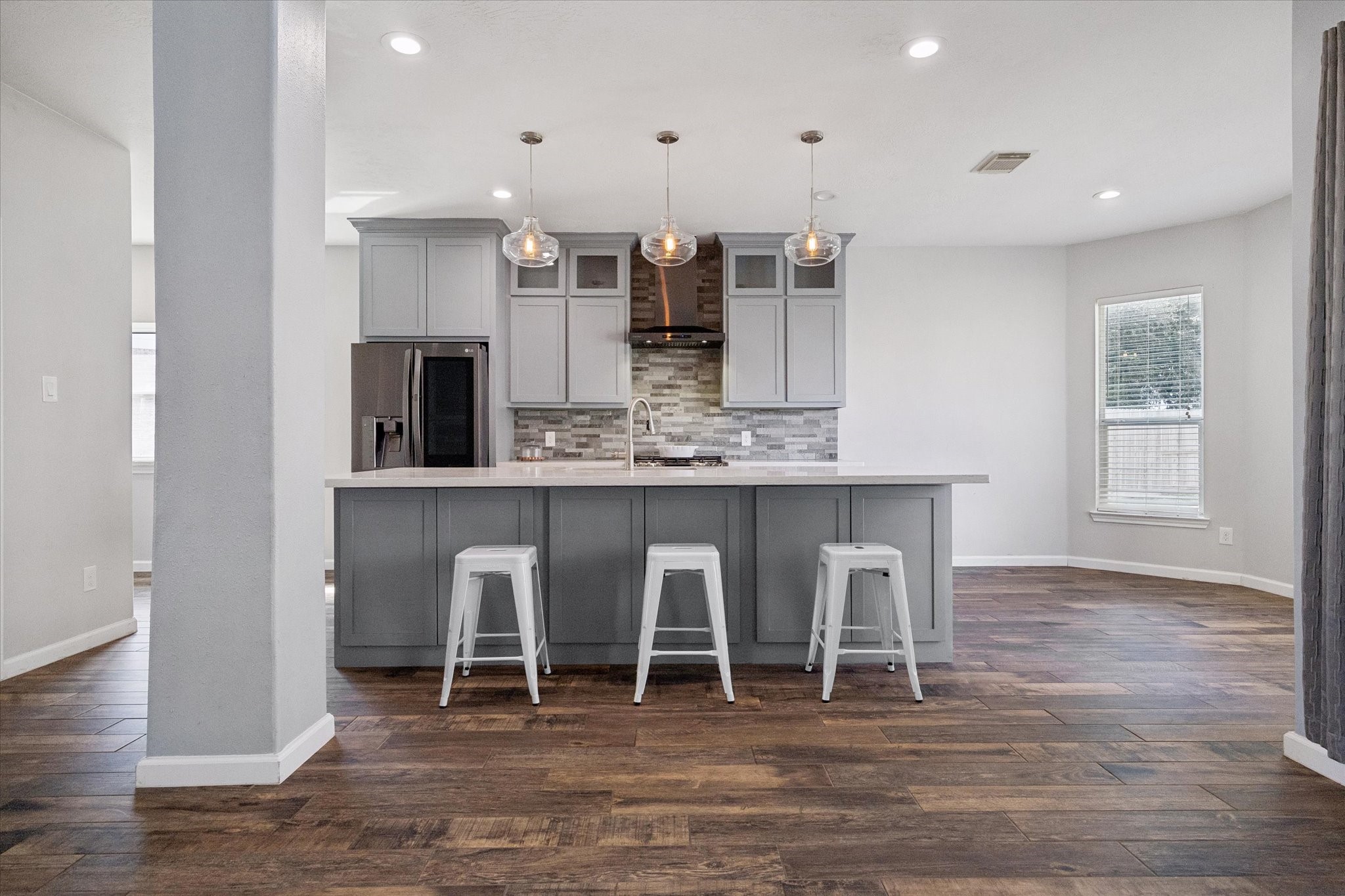 You'll love this MODERNIZED KITCHEN with a huge island, sunny breakfast area, upscale LG appliances, tall cabinets topped with stacked glass-front cabinets, and more!