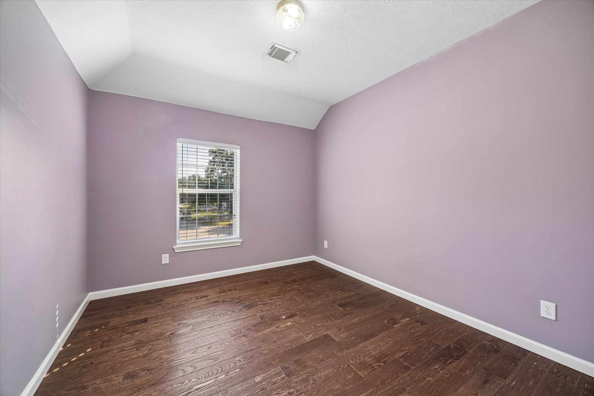 A cheery third guest bedroom upstairs overlooks the front yard.
