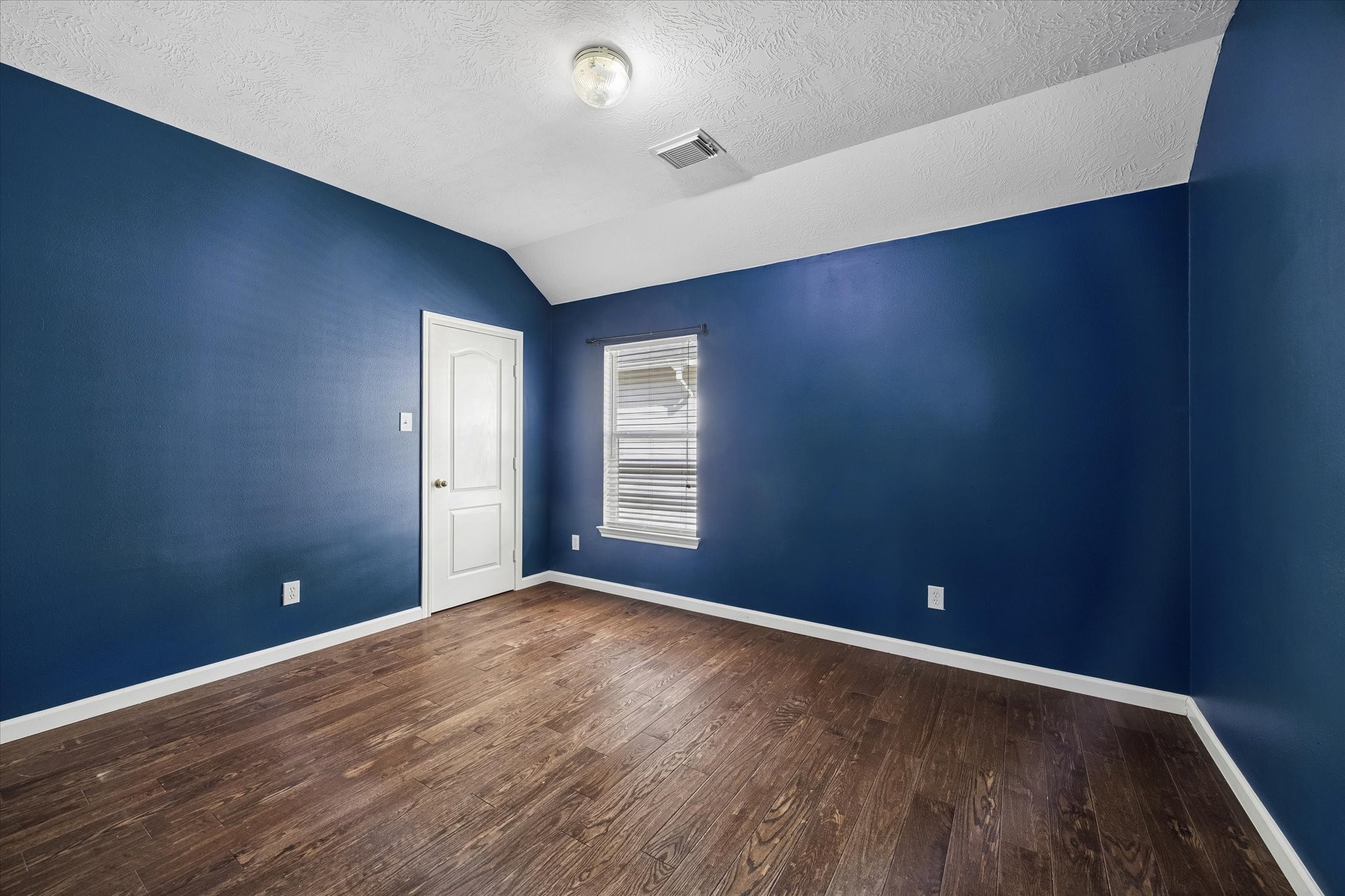 Second guest bedroom - great size, high ceiling, big closet, and wood flooring!