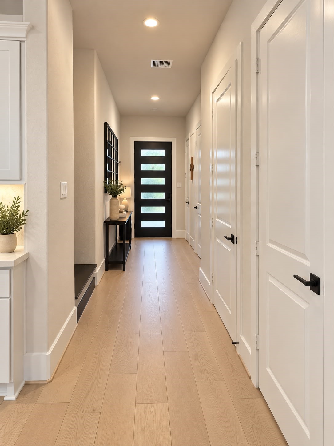 Welcoming entry hallway with a modern front door, recessed lighting, light wood-look flooring, and clean contemporary finishes.