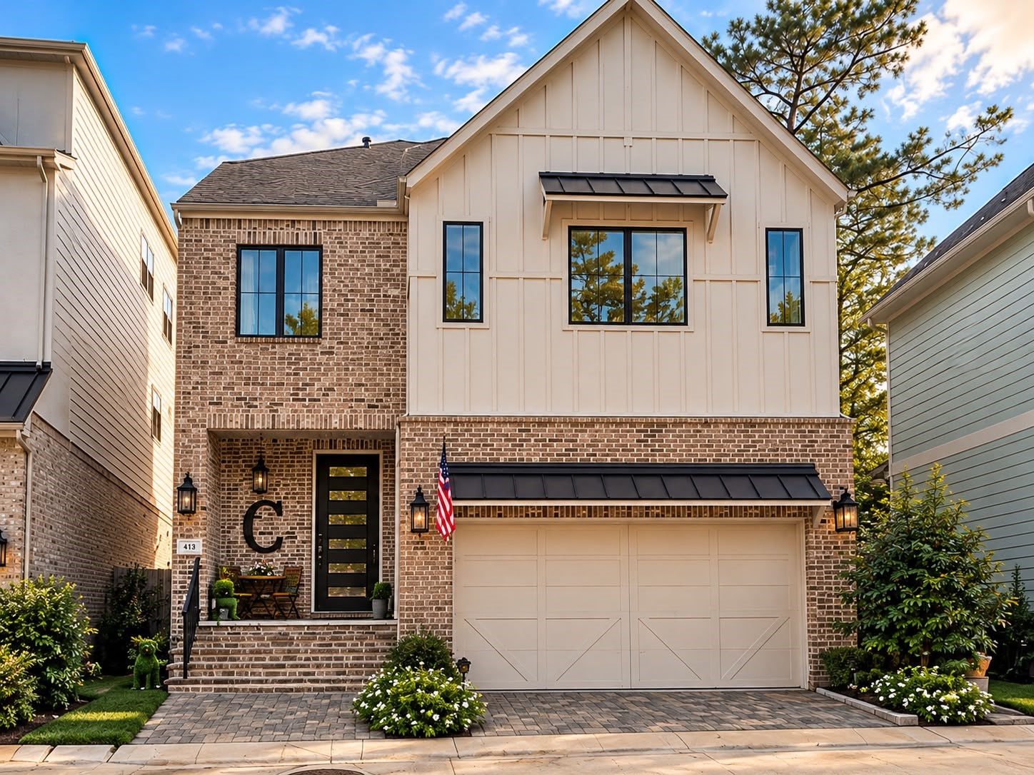 Beautiful two-story home featuring a brick and board-and-batten exterior, modern black-framed windows, a covered entry, and an attached two-car garage.