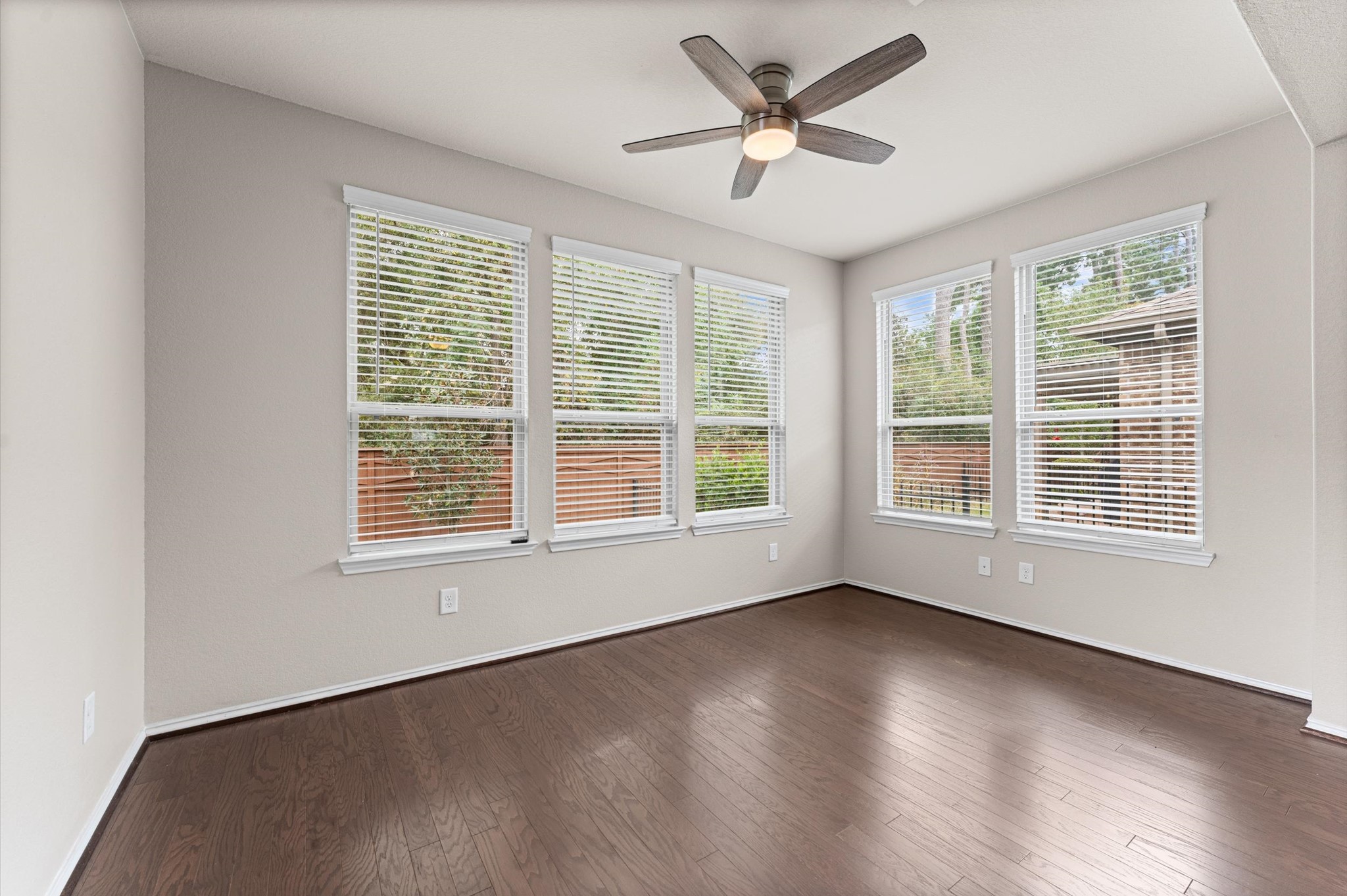 A sunroom designed around sweeping views of the green space behind your property serves as the ultimate transitional bridge between indoor comfort and outdoor serenity.