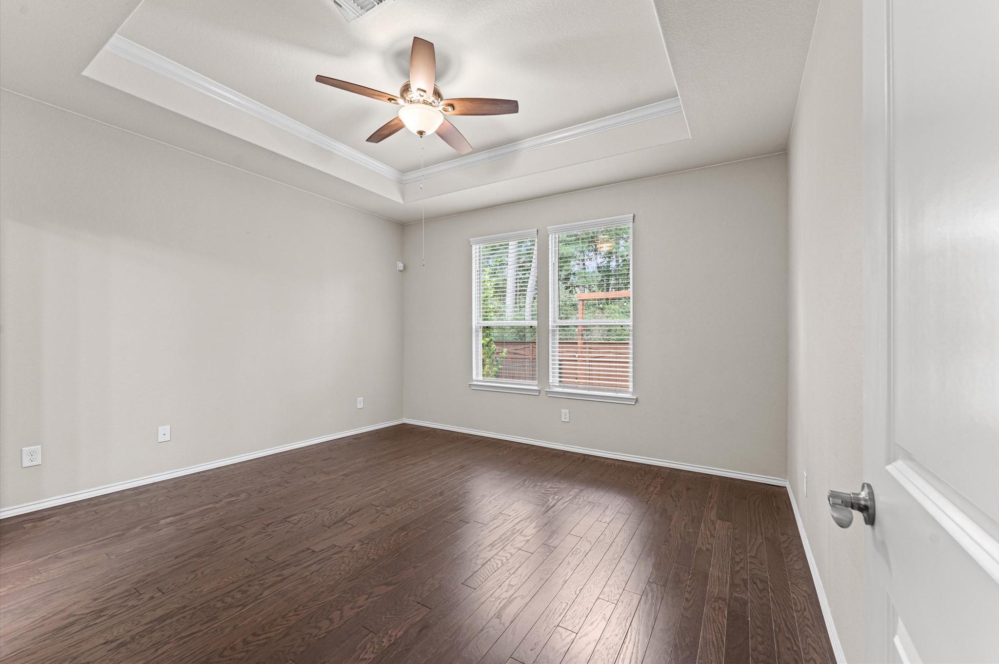 The spacious and inviting primary suite features high ceilings, a beautiful view to the green space behind the property and modern en-suite bathroom.