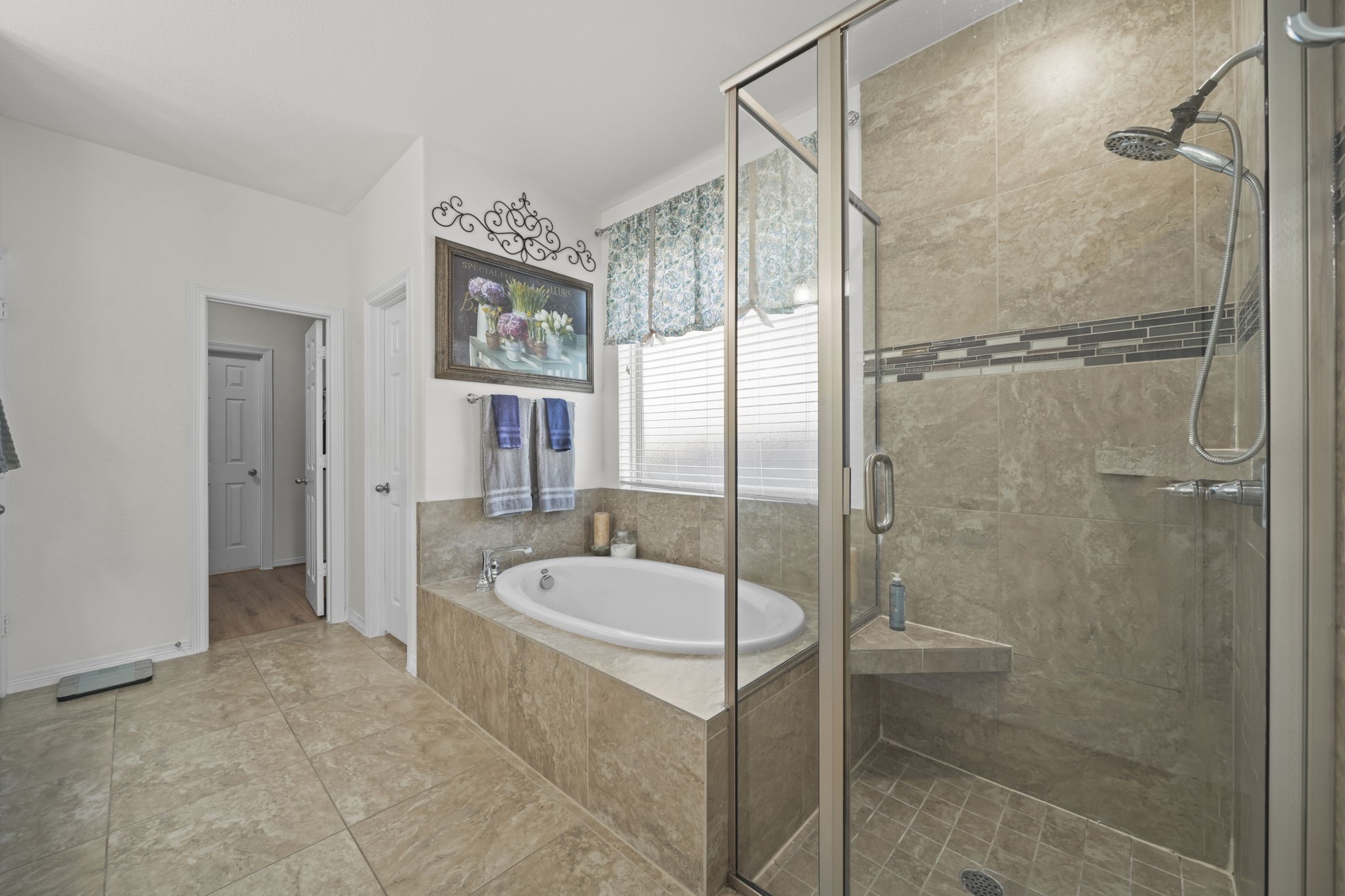 Luxurious bathroom featuring a spacious walk-in shower and a relaxing soaking tub, accented by elegant tile work and ample natural light.